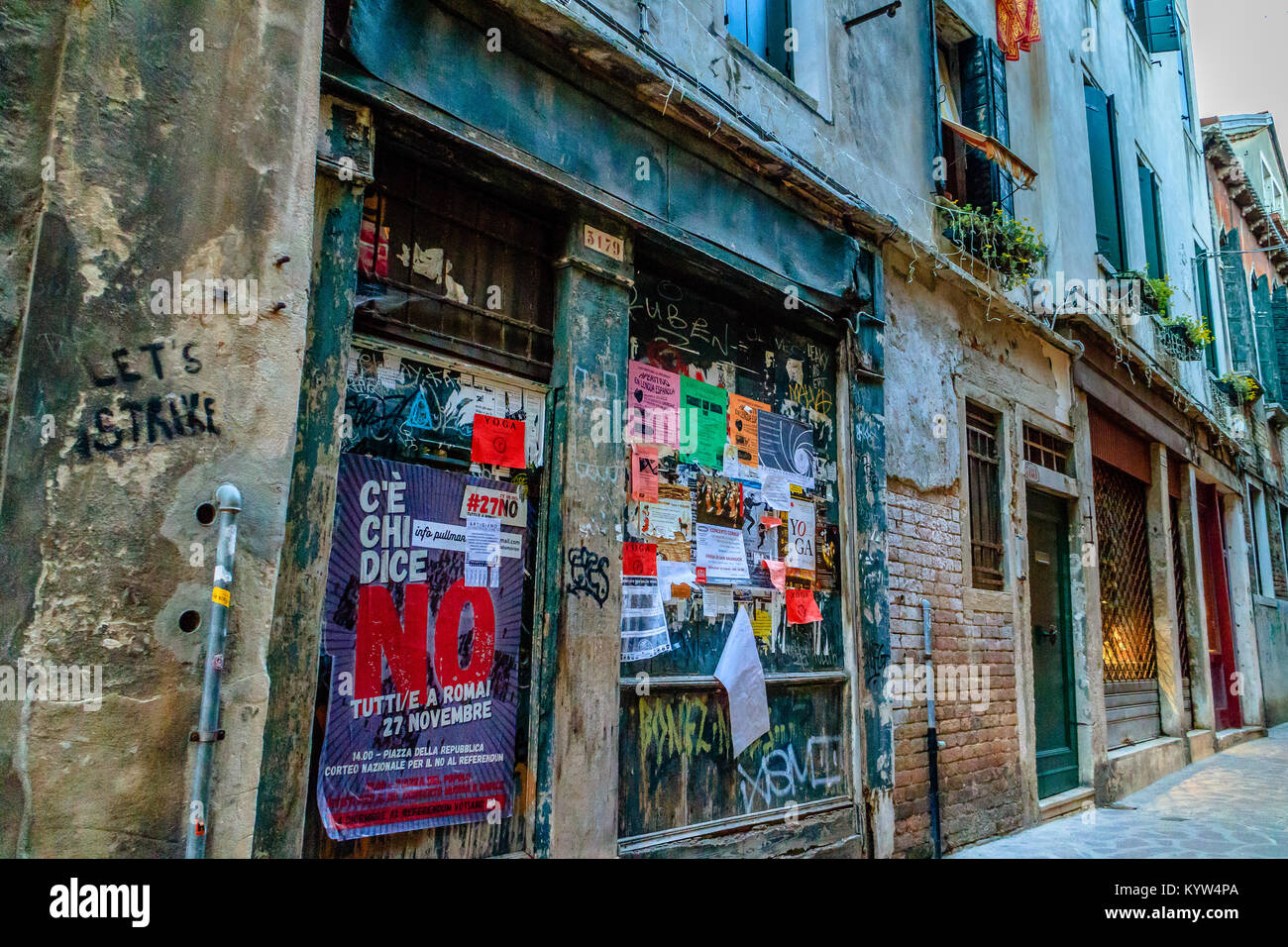 Politica locale e poster imperniato ad un negozio di vuoto anteriore, su una strada laterale nel centro di Venezia, Italia. Aprile 2017. Foto Stock