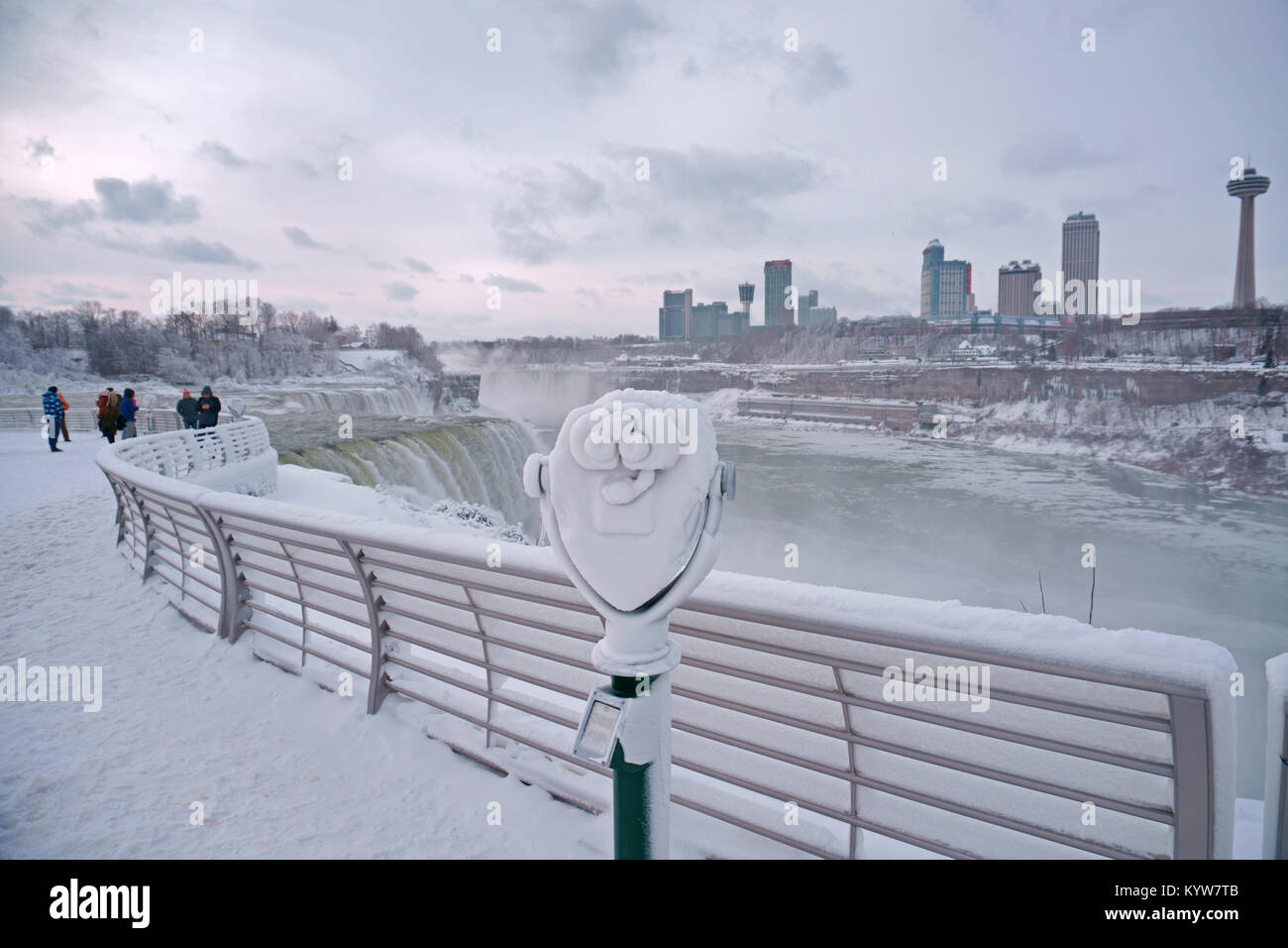 Cascate del Niagara parco dello Stato di New York, Stati Uniti d'America, con visitatori visitano il parzialmente congelati cascate in lavori di soffiaggio della neve, la vedetta binocolo in foregroun Foto Stock