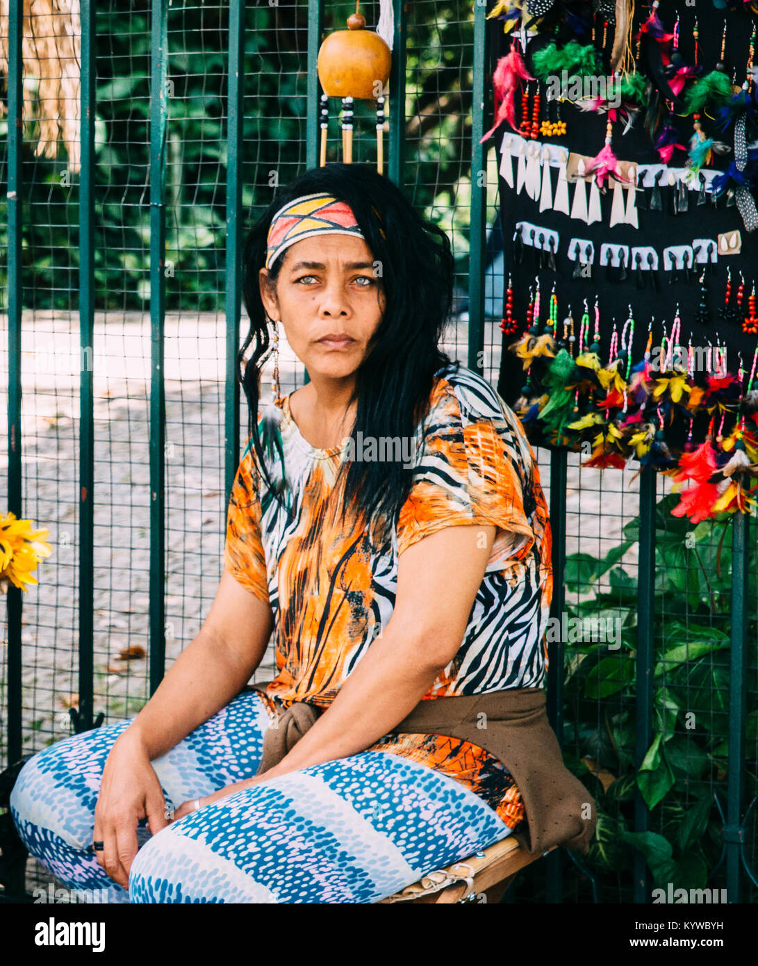 Lo sguardo preoccupato di razza mista brasiliano della donna indigena la vendita di merci in un mercato di strada a Belo Horizonte, Minas Gerais, Brasile Foto Stock