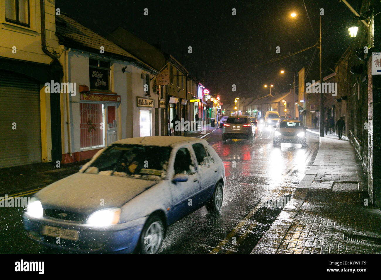 Celbridge, Kildare, Irlanda. 16 gennaio, 2018. L'Irlanda Meteo - Cars driving attraverso Celbridge città in una forte nevicata Foto Stock