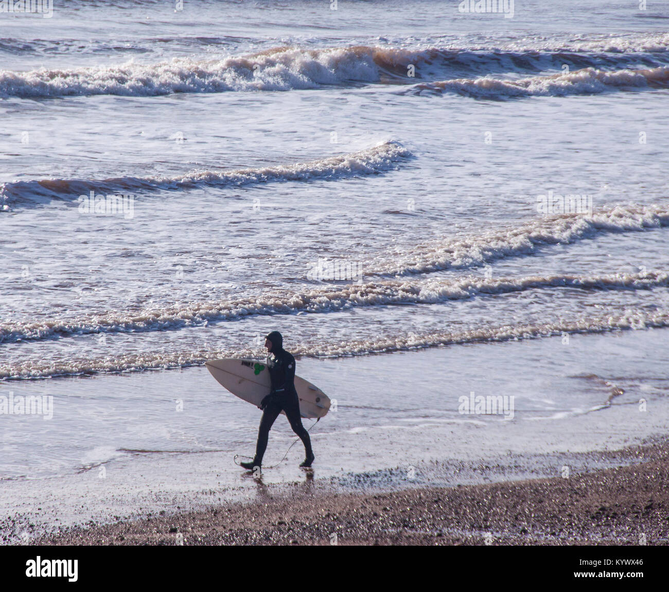 Sidmouth, 17 gen 2018. Un surfista teste fuori in cerca di un'onda in una giornata di sole a Sidmouth, nel Devon. Credit: Foto centrale/Alamy Live News Foto Stock