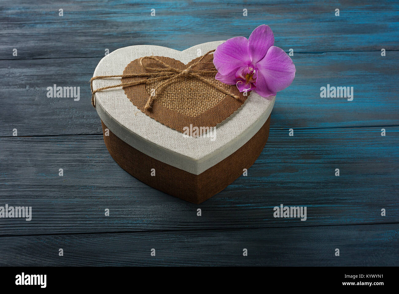 Confezione regalo a forma di cuore sul blu sullo sfondo di legno Foto Stock