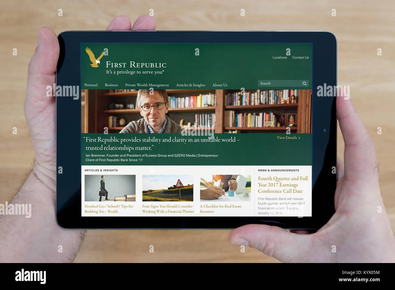 Un uomo guarda la prima repubblica sito web della banca sul suo iPad dispositivo tablet pc, con un tavolo di legno top sfondo (solo uso editoriale) Foto Stock