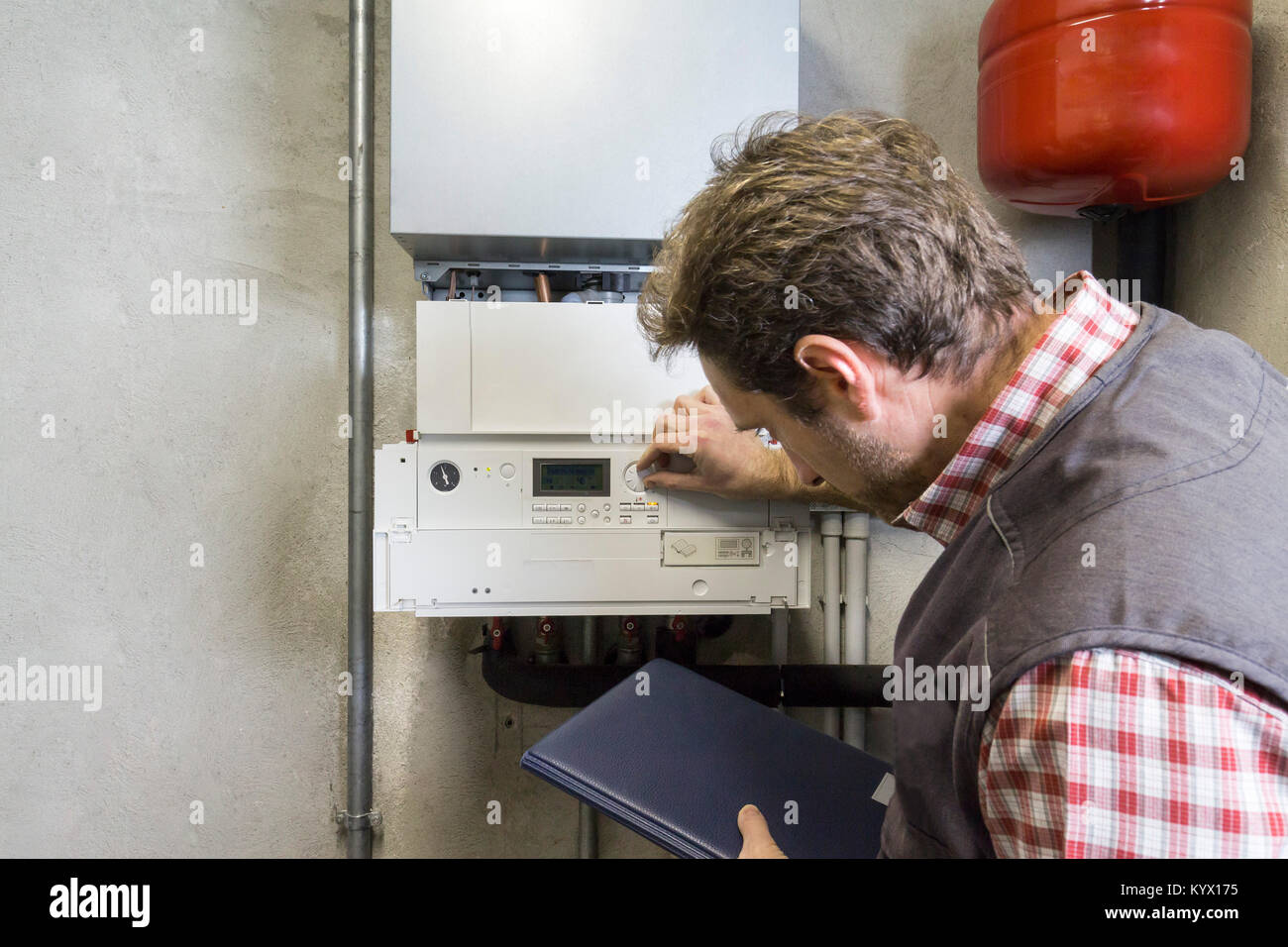 Plumber riparazione di una caldaia a condensazione Foto Stock