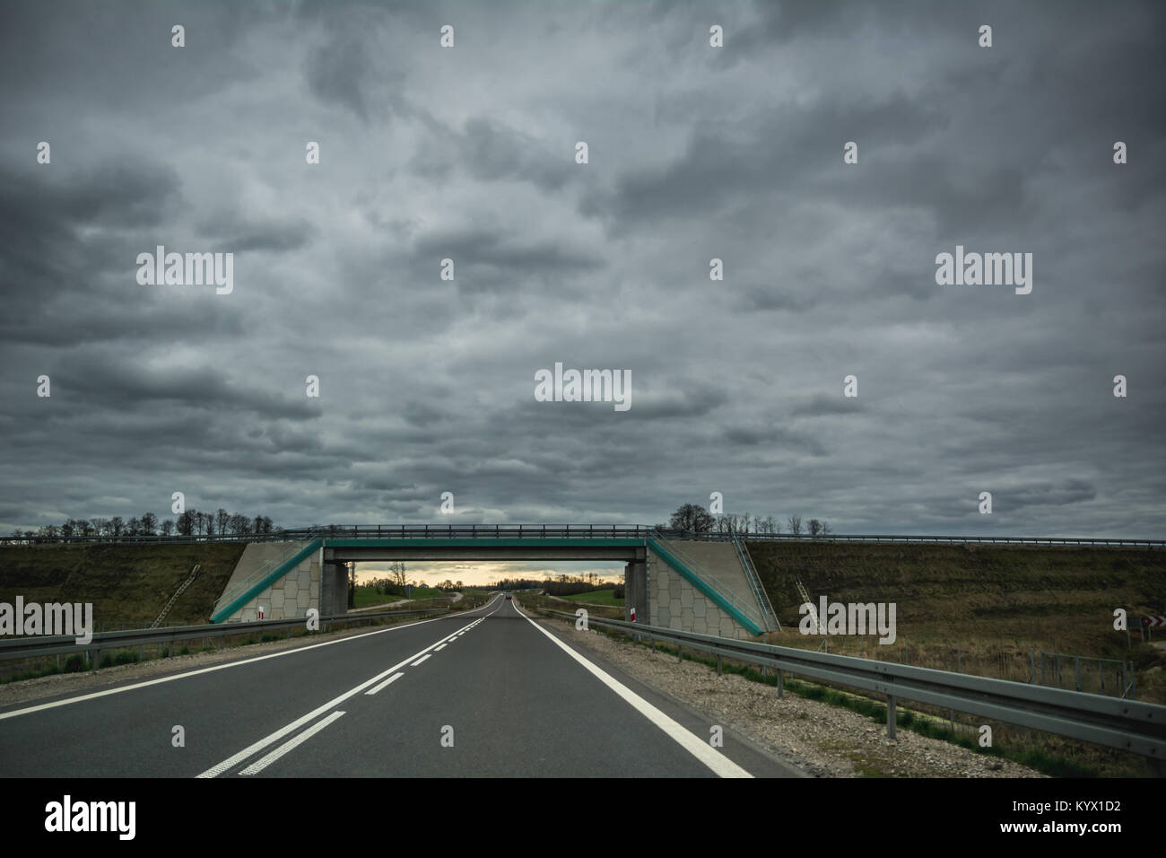 Svuotare strada asfaltata e di un ponte su nuvoloso giorno di estate in Lituania Foto Stock