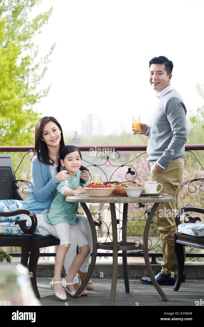 Famiglie felici di mangiare la prima colazione sulla terrazza Foto Stock