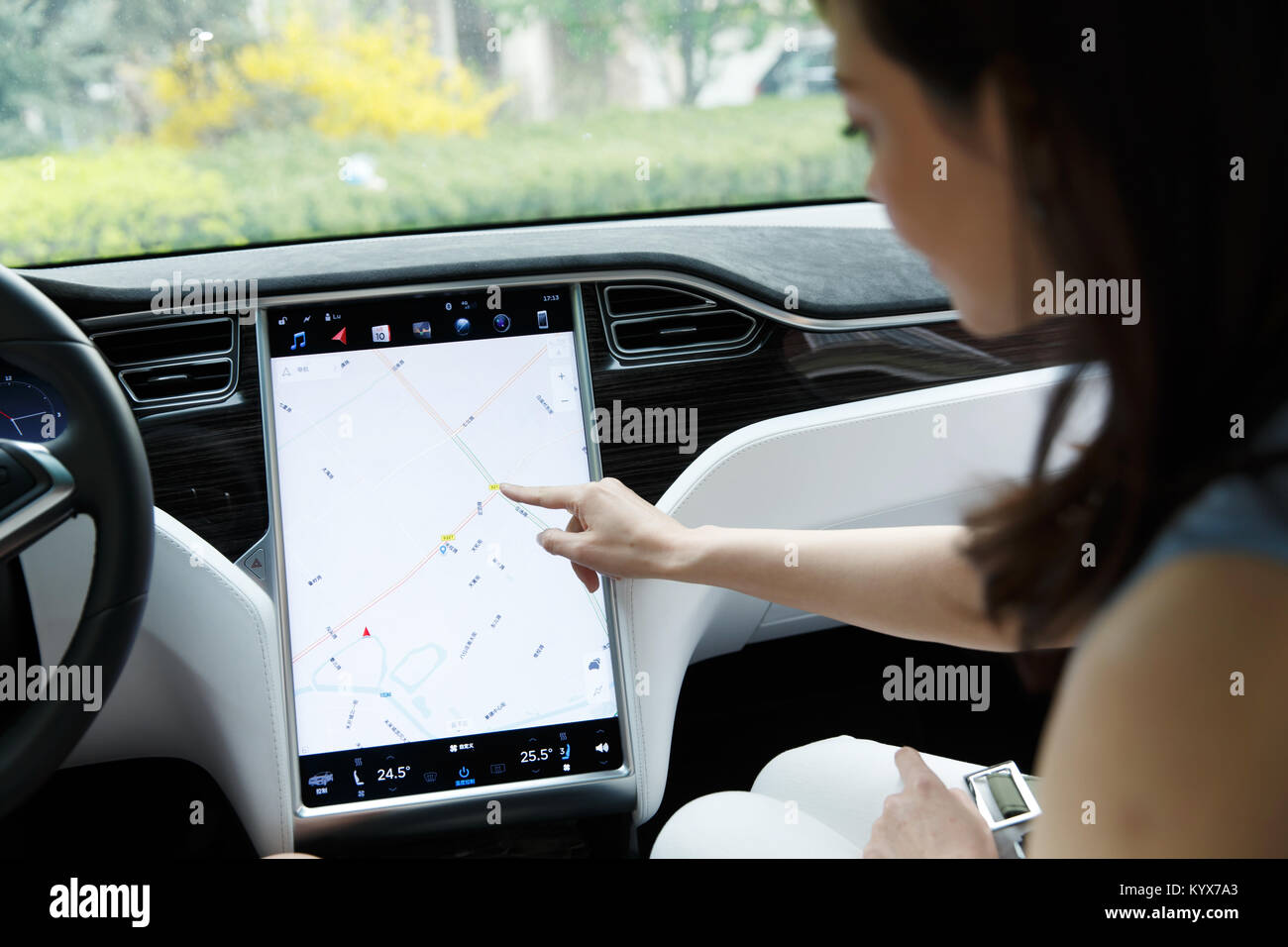 A woman uses a navigator to drive a car Foto Stock