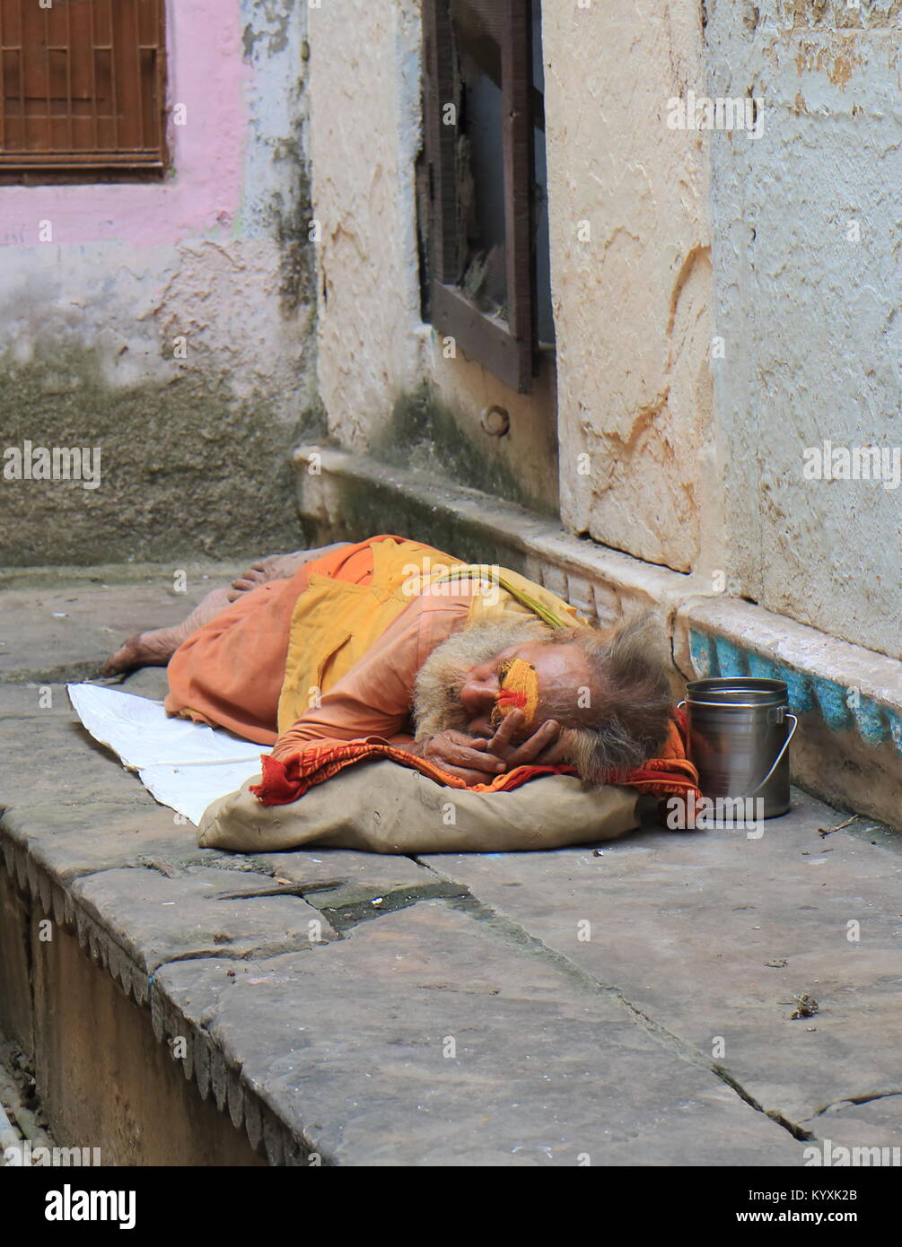 Indian uomo dorme sulla strada di Varanasi India. Foto Stock