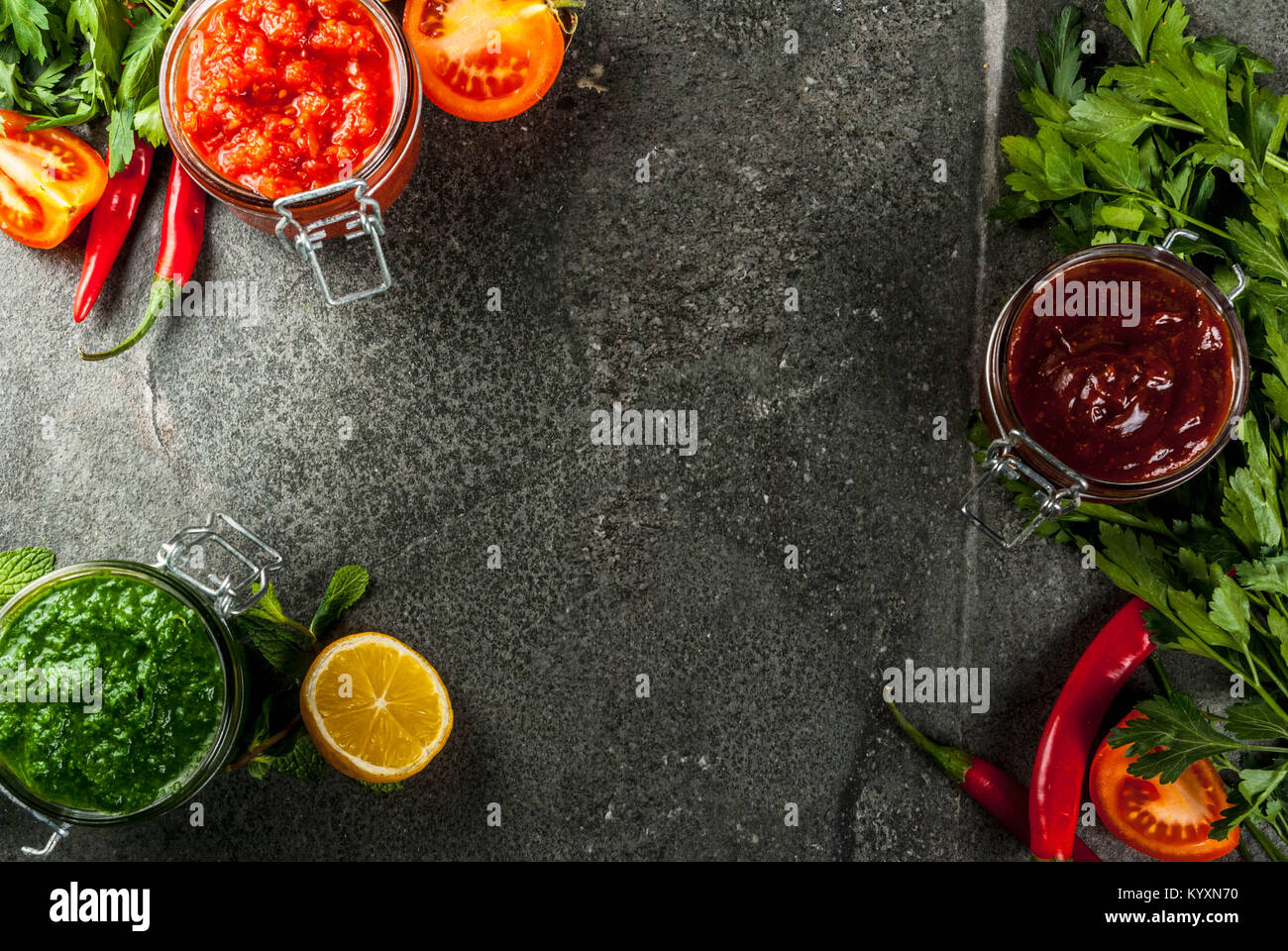 Indian cibo tradizionale, Set di tre chutney per Chaat e Sev Puri - dolce data-tamarindo, il coriandolo-verde menta e il peperoncino rosso aglio, sulla pietra scura b Foto Stock