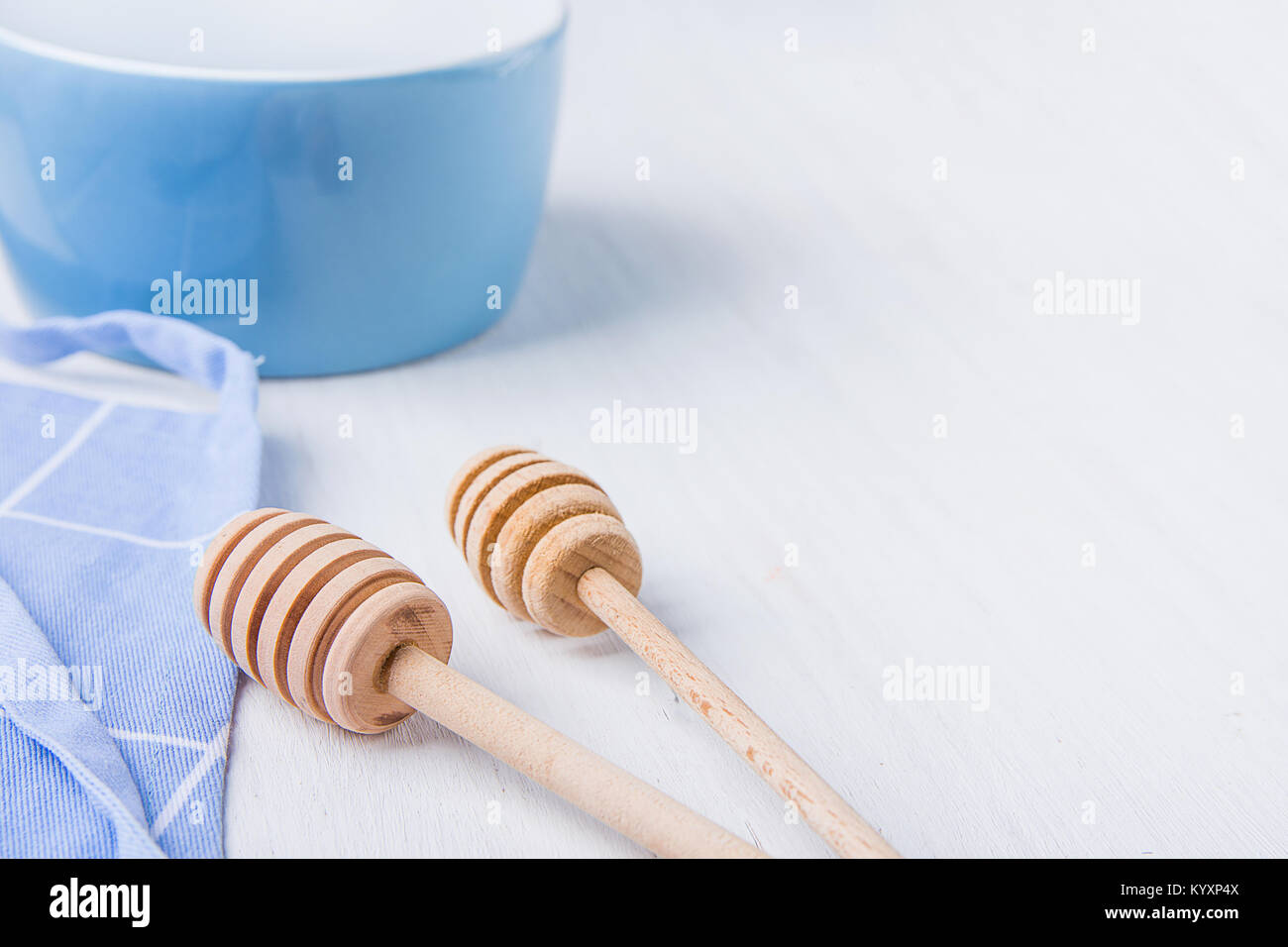 Blue Recipiente vuoto di miele di legno campionatori a immersione cucchiai grembiule cotone bianco sul tavolo. Holiday cottura concetto di cucina a vista. Natale Pasqua. Cucina interna. Mi sociale Foto Stock