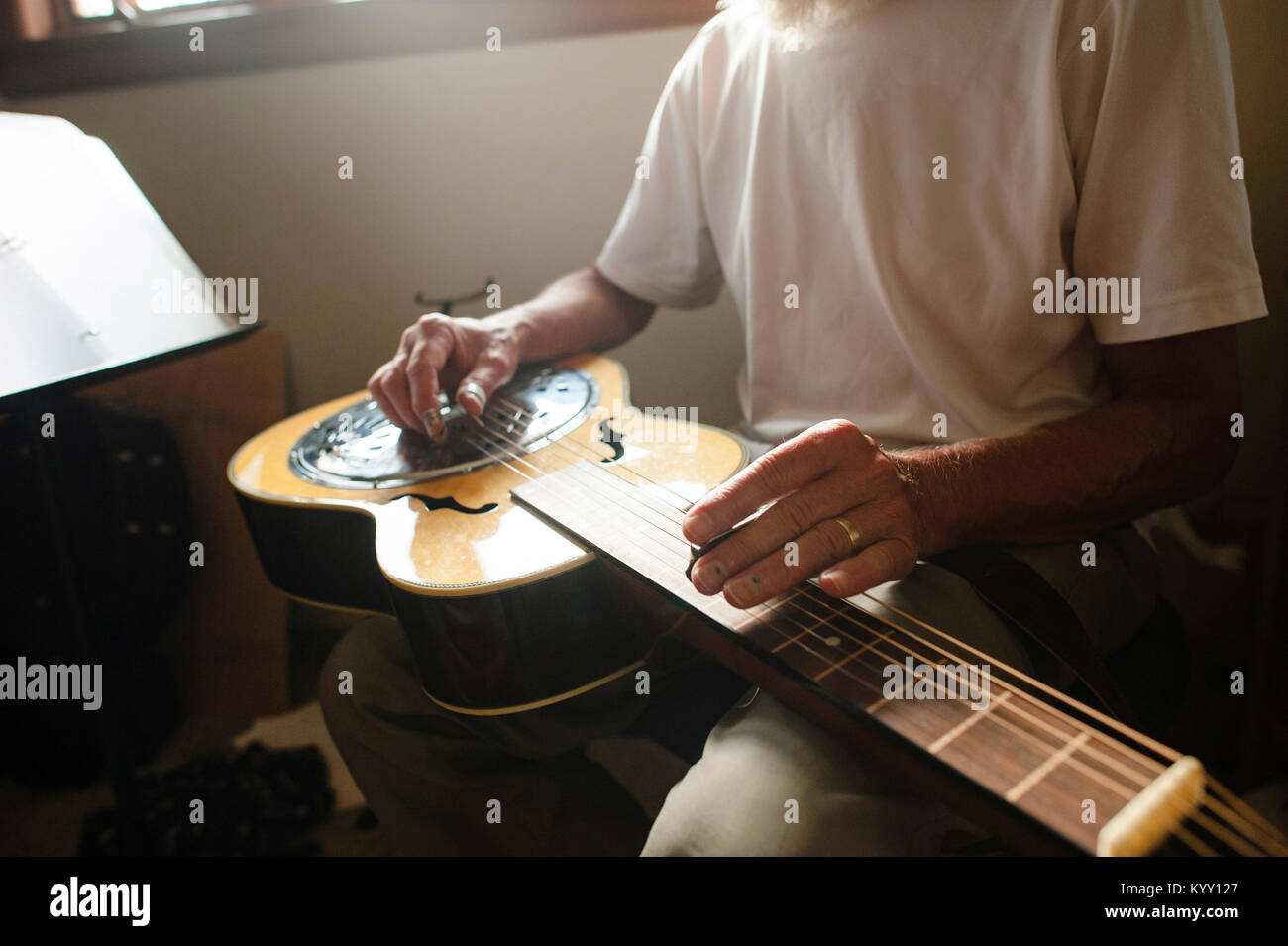 Sezione mediana di senior uomo imparare la chitarra a casa Foto Stock