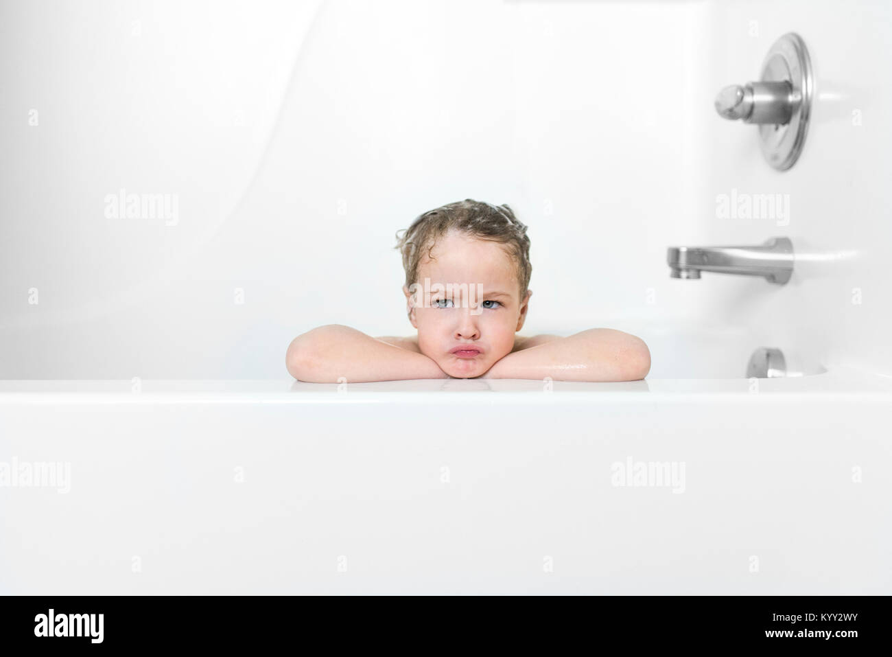 Arrabbiato ragazzo che faccia nella vasca da bagno Foto Stock