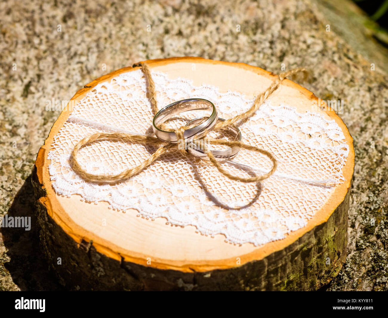 Gli anelli di nozze giacciono su di un legno naturale segare Foto Stock