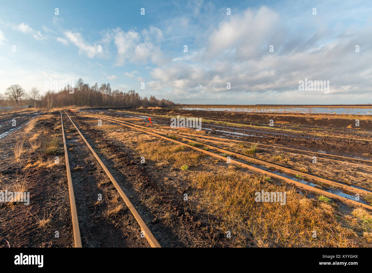 Paesaggio girato di una torba area mineraria con i binari di una ferrovia di torba Foto Stock