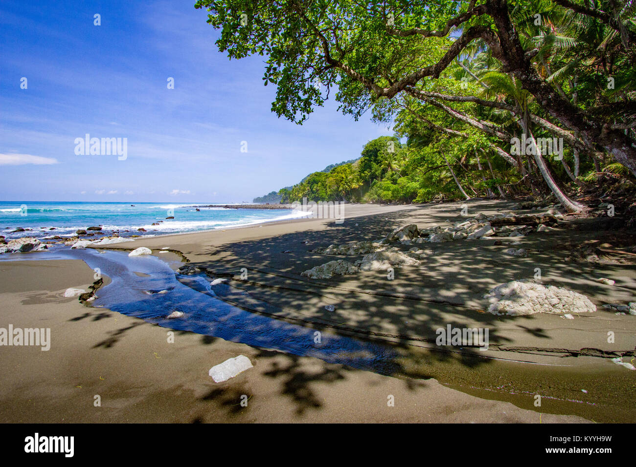 Spiaggia e piccolo ruscello dal maritime la foresta pluviale del Parco Nazionale di Corcovado sulla penisola di Osa in Costa Rica Foto Stock