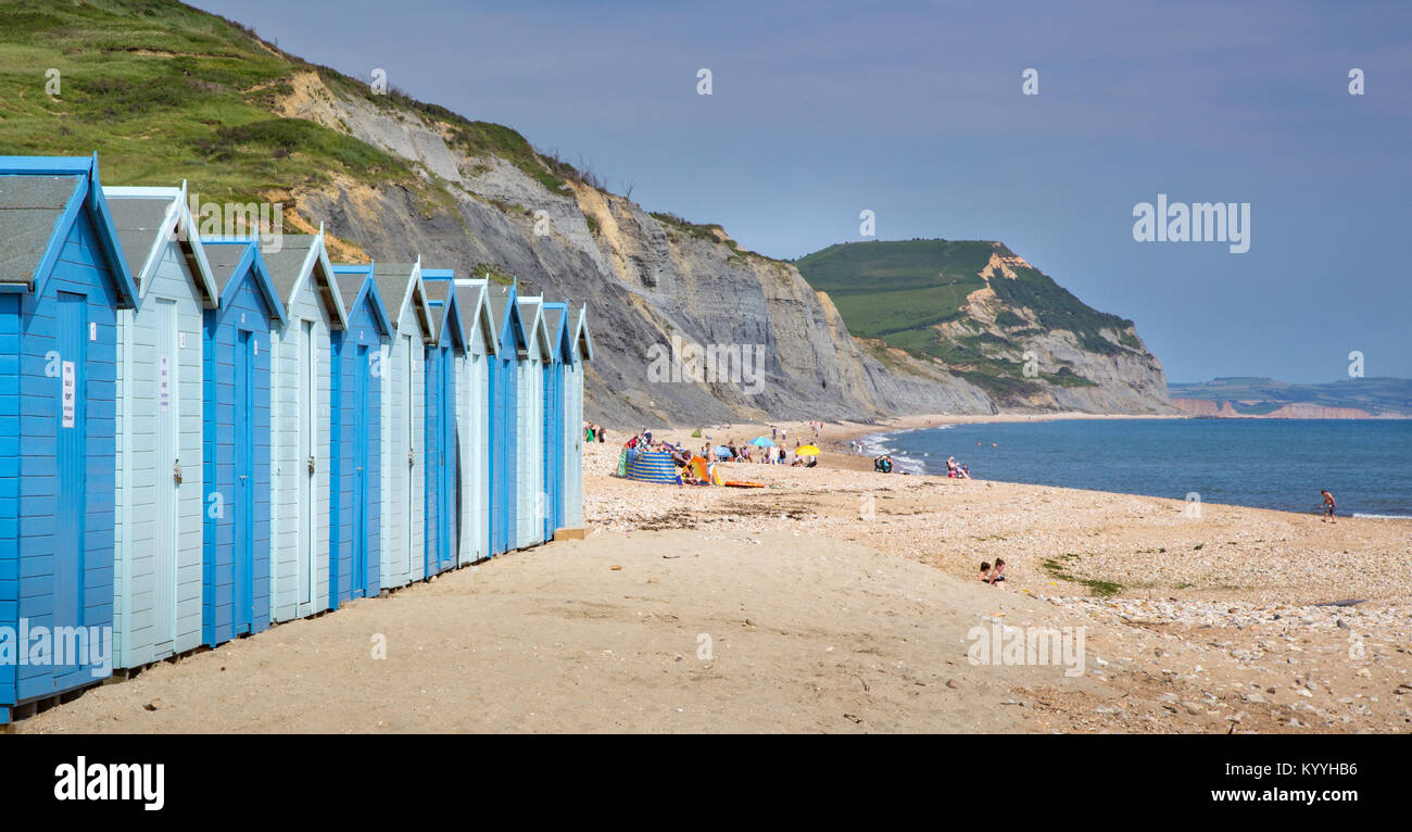 Blue beach capanne a Charmouth sulla spiaggia la costa del Dorset con Golden Cap in distanza Foto Stock