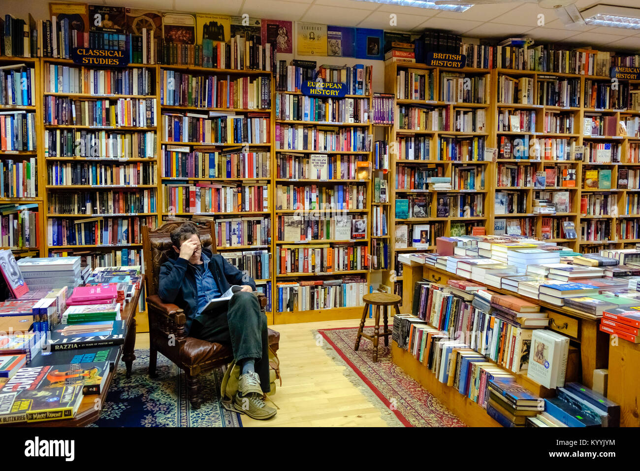 Bookshop interni - Uomo leggendo un libro all'interno Charlie Byrne's Bookshop a Galway, Irlanda Foto Stock