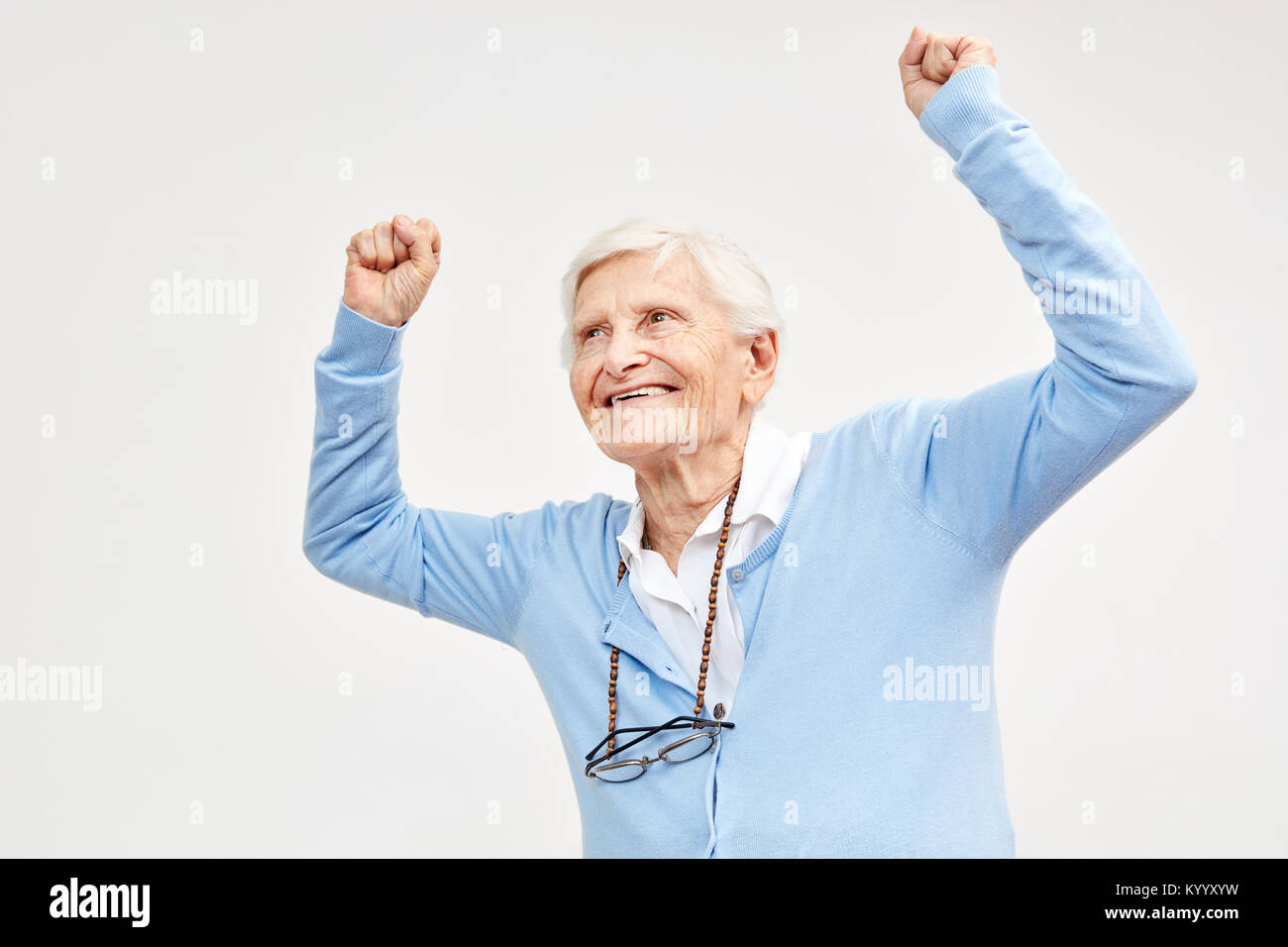 Senior celebra con rinserrata pugni come un segno di gioia per la vita e la vitalità Foto Stock