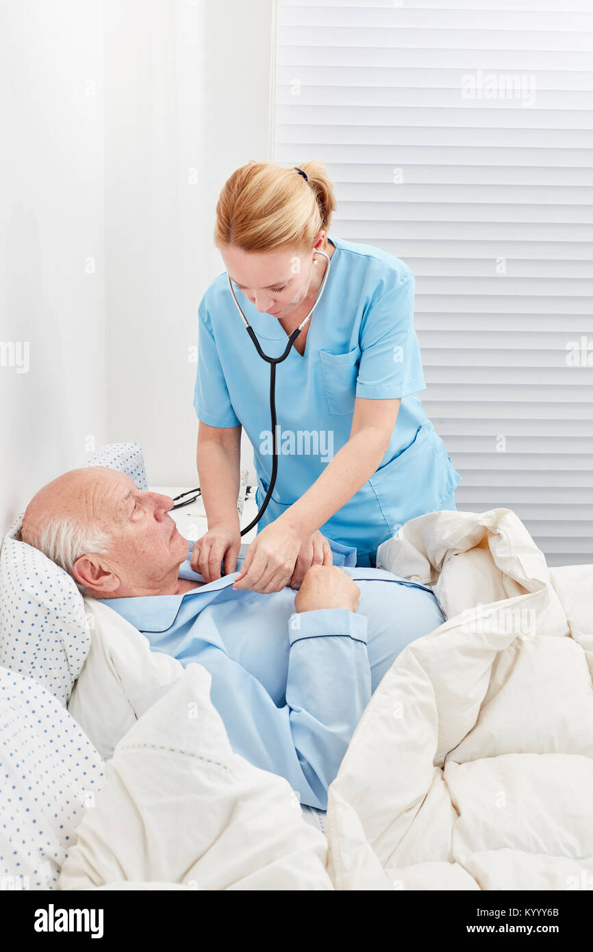 Donne medico o infermiere controlla la respirazione del paziente con uno stetoscopio Foto Stock
