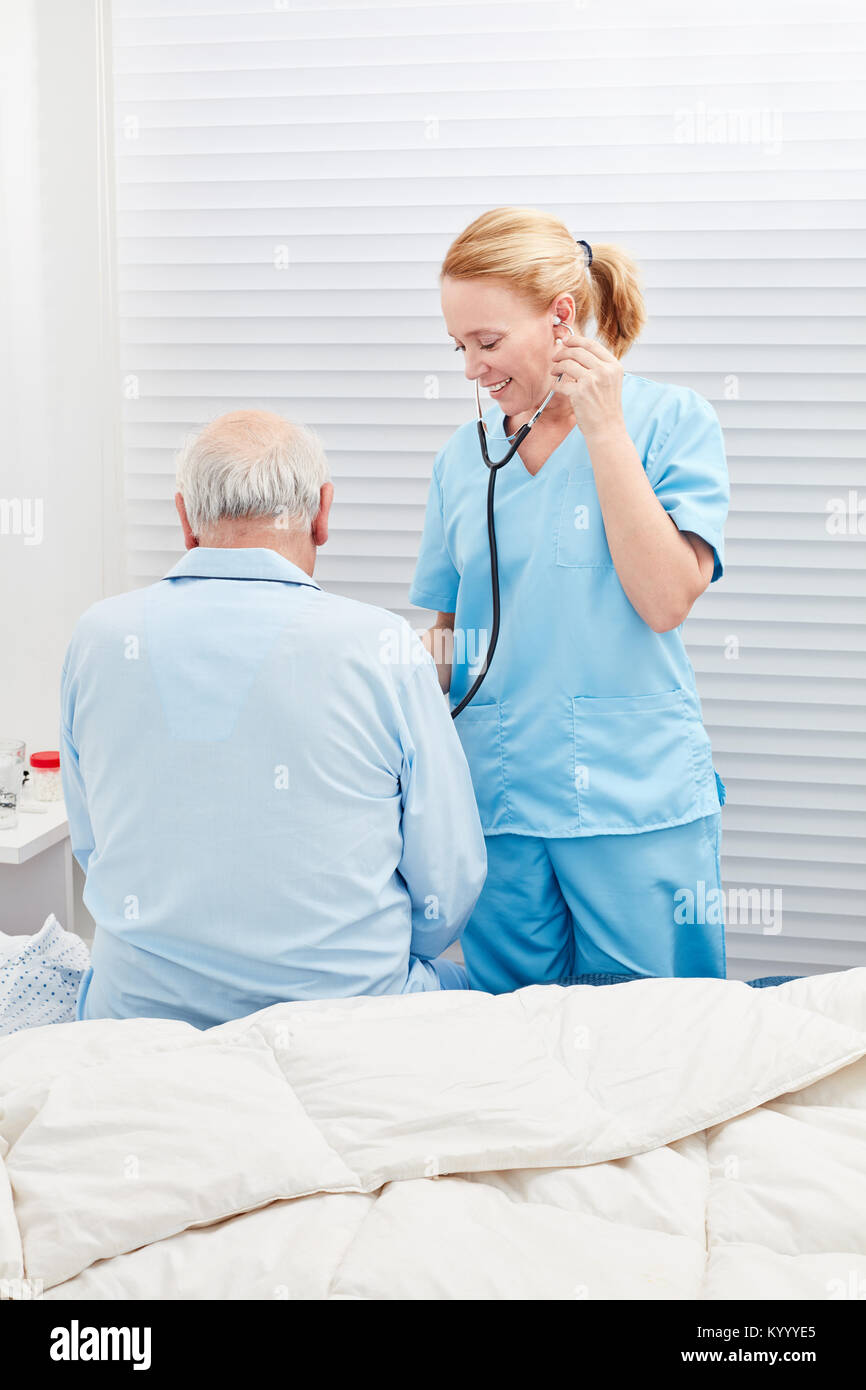 Medico o infermiere ascolta paziente con uno stetoscopio in ospedale Foto Stock