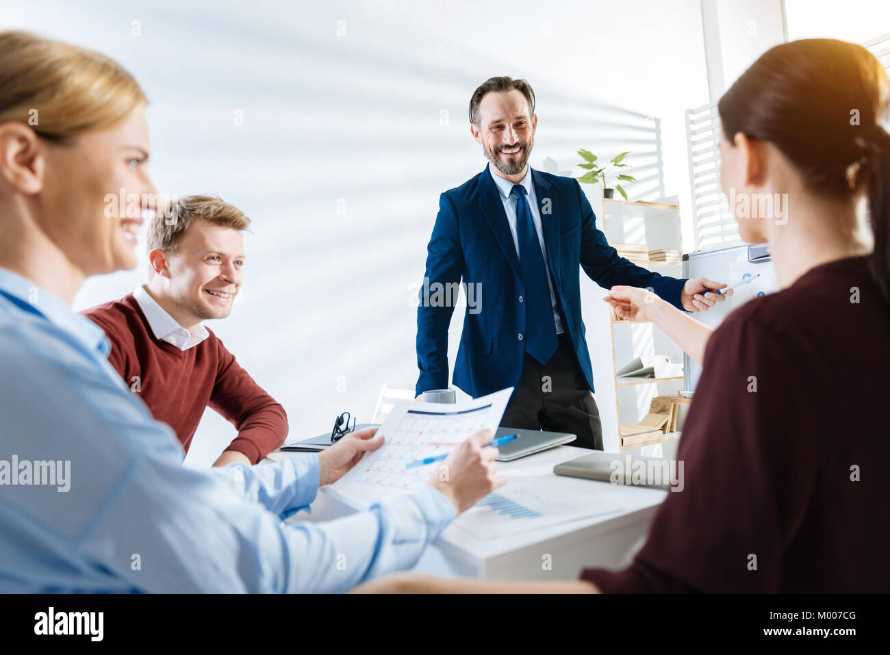 Gioioso quattro colleghi per condividere pensieri Foto Stock