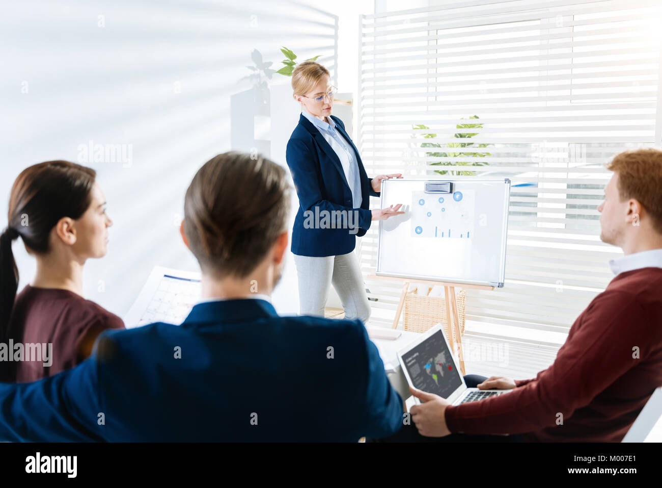 Caparra quattro colleghi che frequentano la presentazione Foto Stock