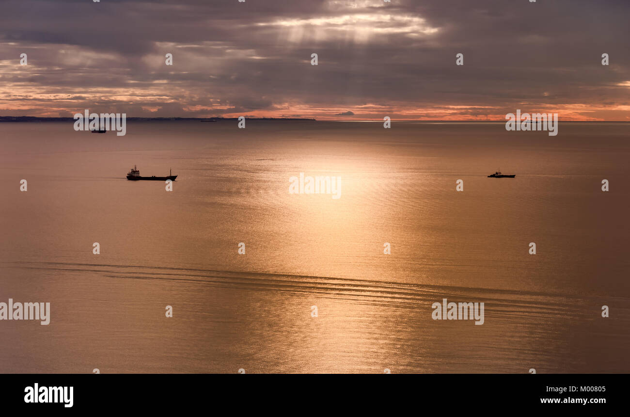 Seascape con navi al tramonto con il cielo nuvoloso. Foto Stock
