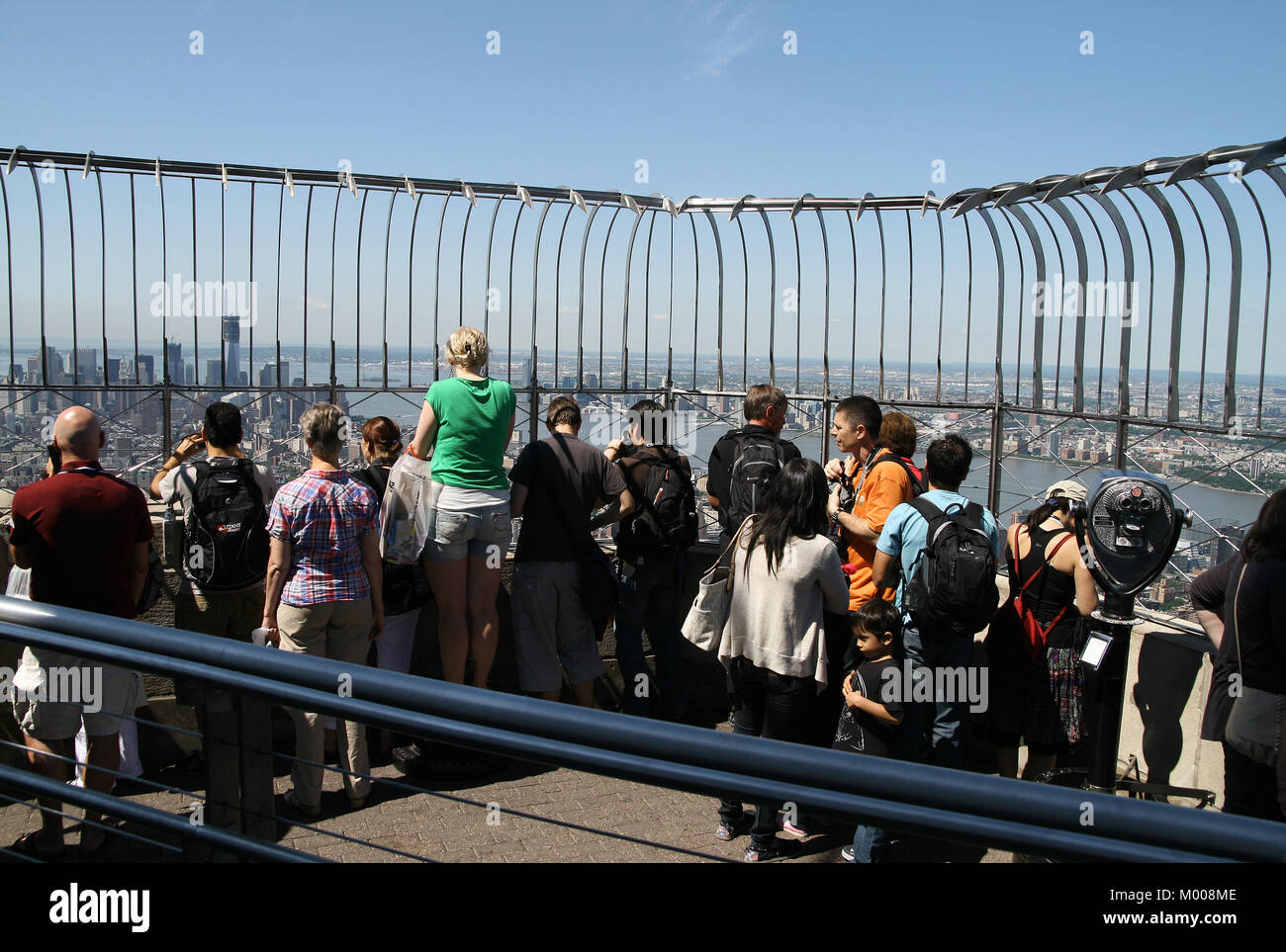 86º piano Observation Deck piena di turisti e di un gettone visualizzazione CANNOCCHIALE BINOCOLO sull'Empire State Building, nello Stato di New York, Stati Uniti d'America Foto Stock