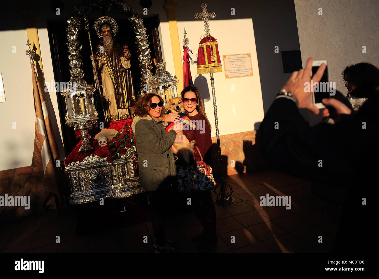 Malaga, Spagna. Xvii gen, 2018. Proprietari di animali domestici che posano per una foto davanti la statua di San Anton al di fuori di San Anton chiesa nel quartiere di Churriana. La festa di San Anton è una tradizione religiosa che si celebra ogni anno in Spagna con tutti i tipi di animali trasportati per i suoi proprietari verso le chiese per sono state benedette da un sacerdote, ricerca la benedizione del Santo patrono degli animali Credito: Gesù Merida/SOPA/ZUMA filo/Alamy Live News Foto Stock