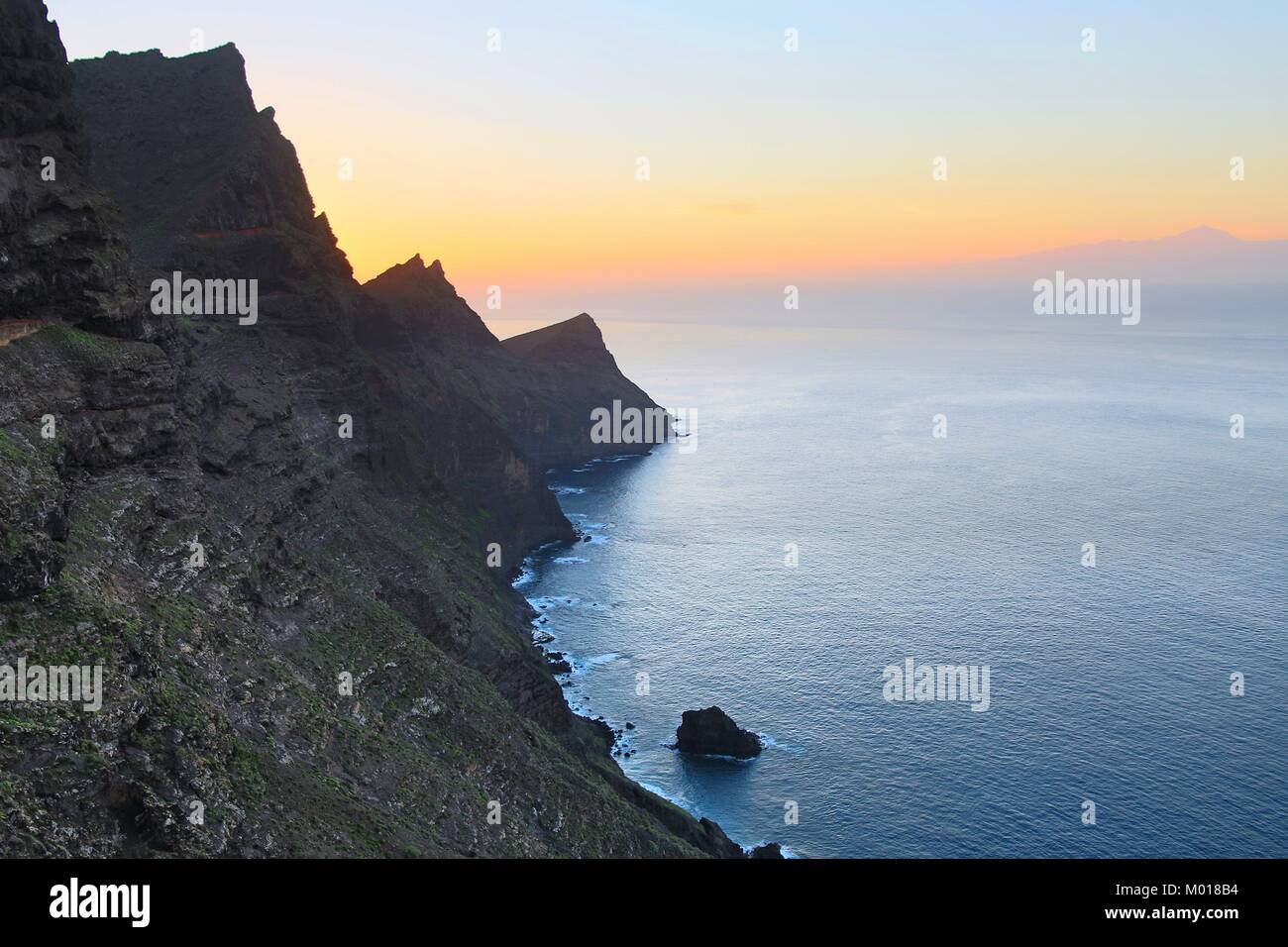 Gran Canaria - scogliere Riscos tramonto con isola di Tenerife in background. Foto Stock