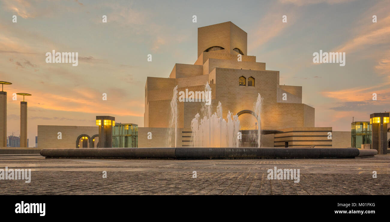 Il Museo di Arte islamica ,,di Doha in Qatar nella luce diurna e vista esterna con fontana in primo piano e le nuvole nel cielo in background Foto Stock