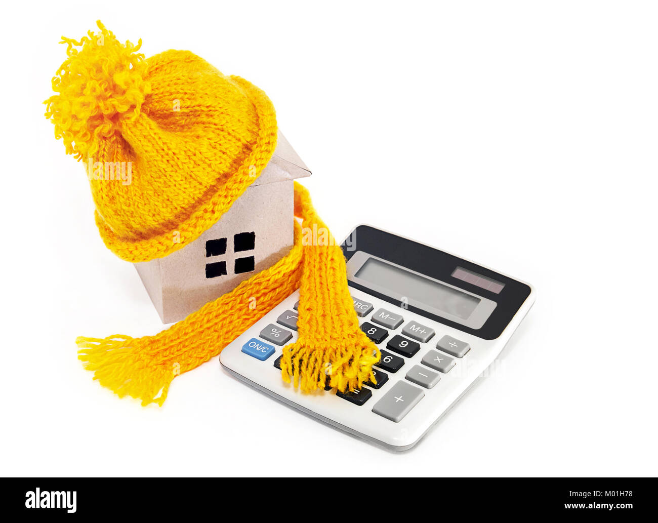 I costi di una casa di isolamento. Casa in un cappello con una sciarpa e una calcolatrice Foto Stock