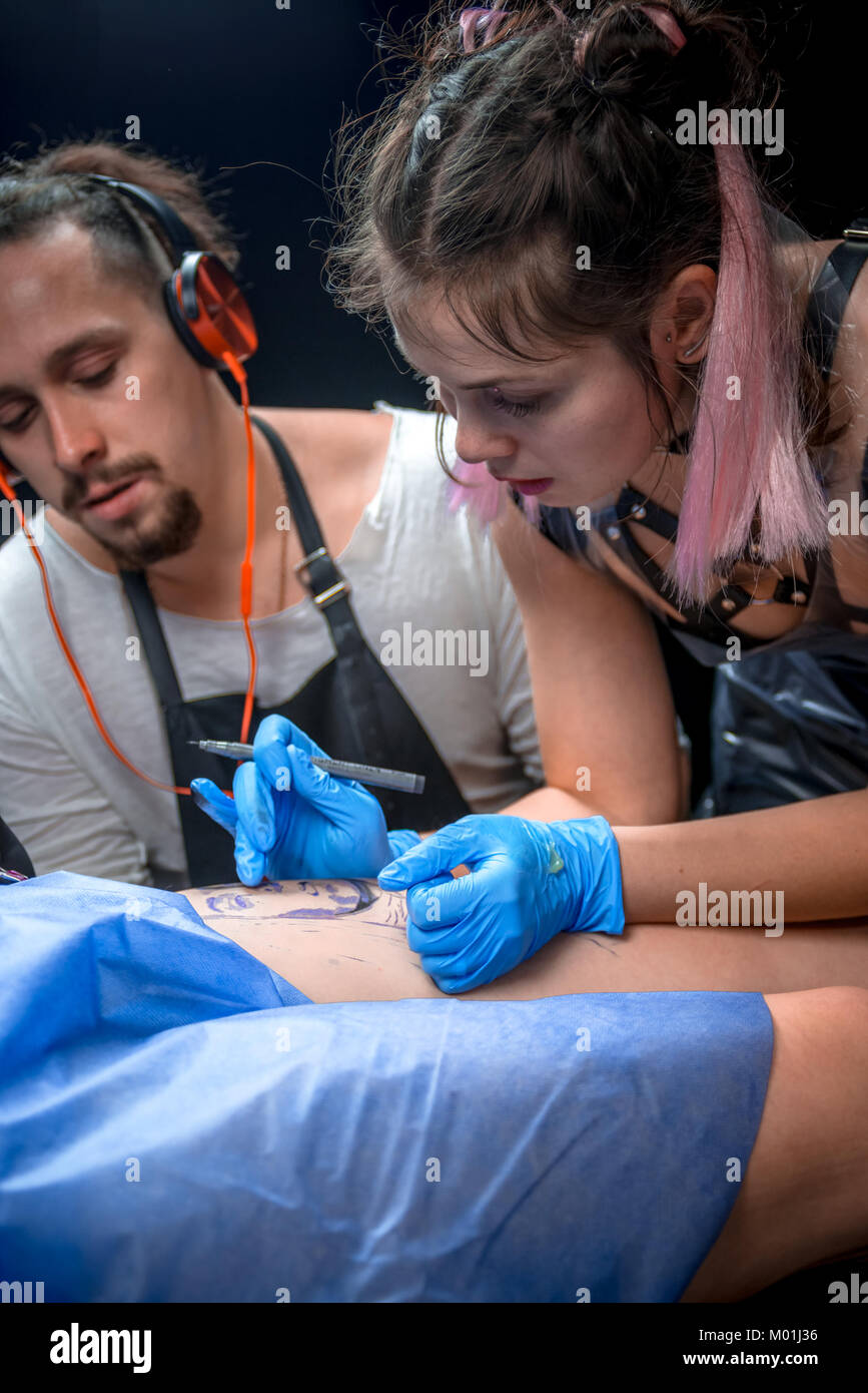 Tatuaggio rendendo master tattoo art nel suo salone. Foto Stock