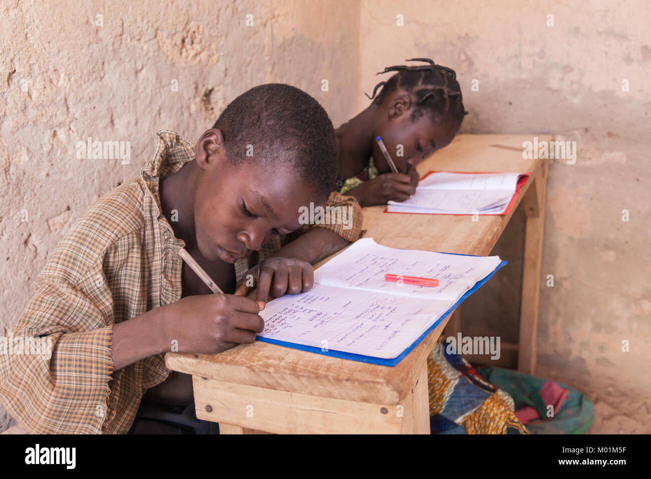 Due paesi africani schoolkids iscritto la lezione in classe, Ouagadougou, Burkina Faso. Foto Stock