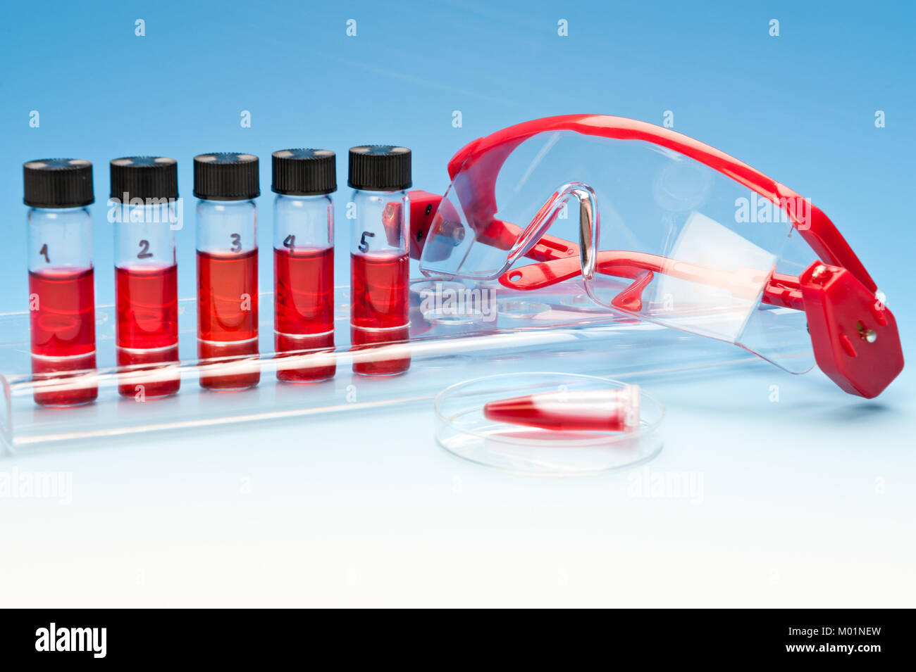 Biologico o i campioni di medicinali e occhiali di sicurezza blu sul gradiente dello sfondo Foto Stock