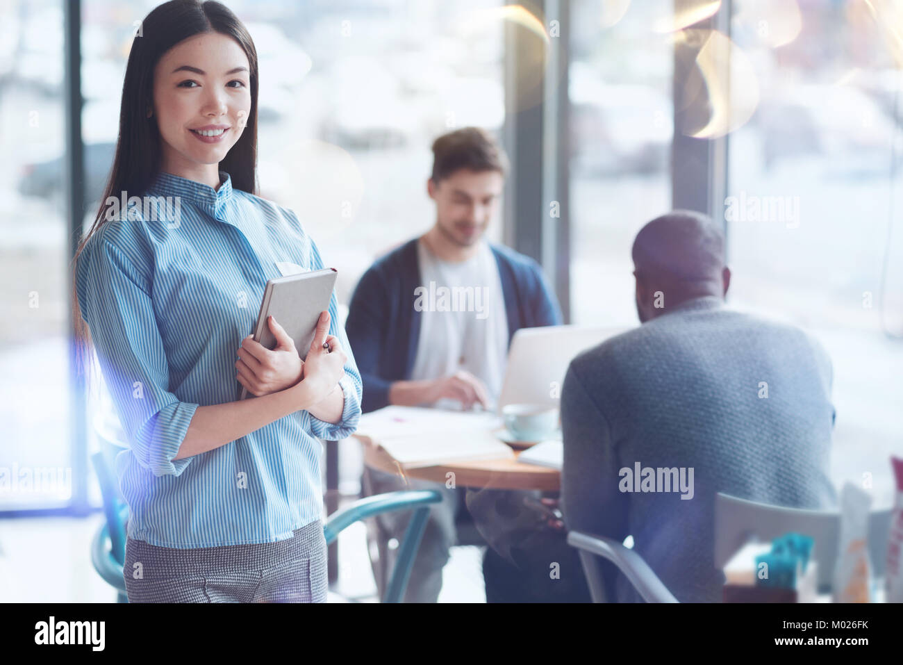 Positivo internazionale felice ragazza con il suo notebook Foto Stock