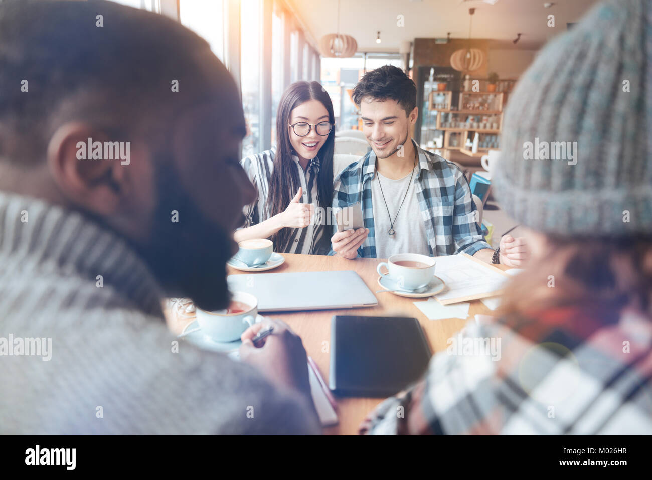 Positivo il piacere giovane guardando lo schermo del telefono cellulare Foto Stock