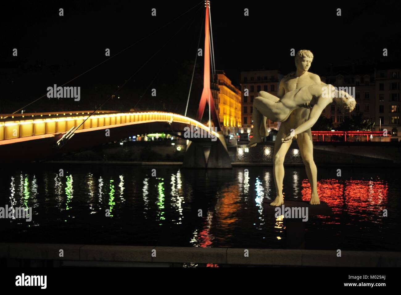 Statua "il peso di se stessi' r fiume Saône in Lyon chiamando per indvidual e responsabilità civica di fronte spettacolare sfondo illuminato Foto Stock