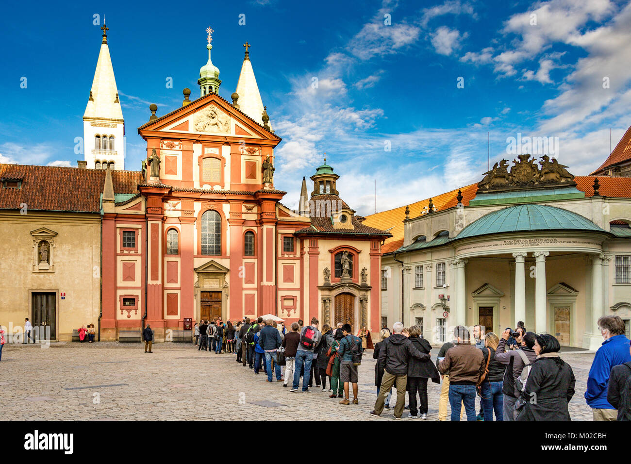 I turisti e i visitatori si accodano per entrare nella Basilica di San Giorgio all'interno del complesso del Castello di Praga, Praga, Repubblica Ceca Foto Stock