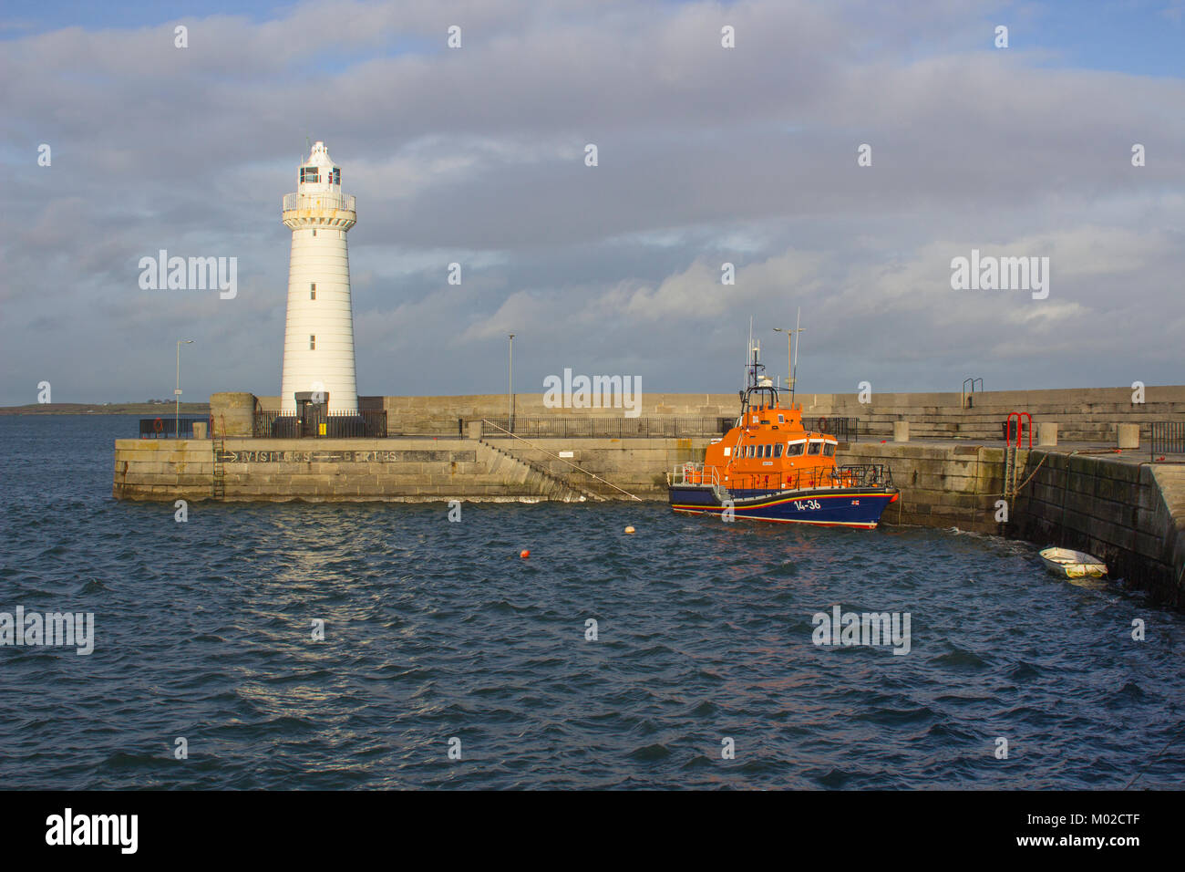 La famosa torre rastremata faro automatico costruito con pietra calcarea tagliata sul molo del porto in Donaghadee nella contea di Down in Irlanda del Nord Foto Stock