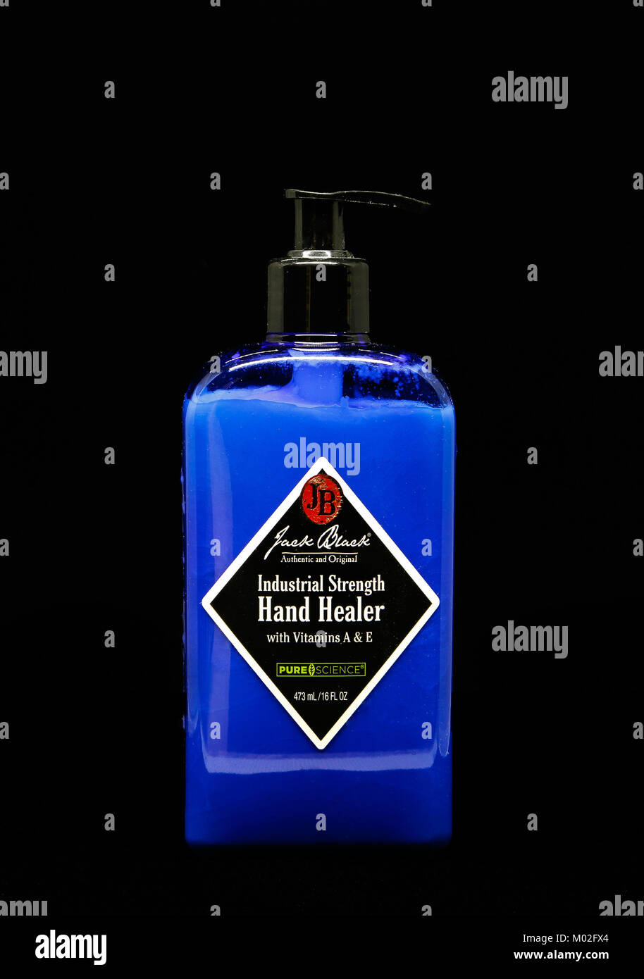 Bottiglia di Jack Black forza industriale canto guaritore si erge contro lo sfondo nero. Foto Stock