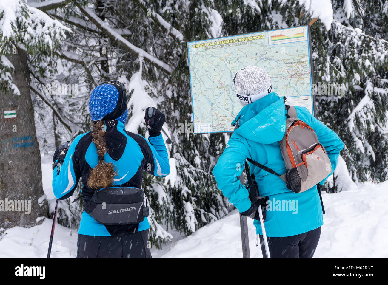Due donne gli sciatori in cerca di un cross-country percorso sulla mappa. Jakuszyce, Giant Monti Karkonosze, Polonia, l'Europa. Foto Stock