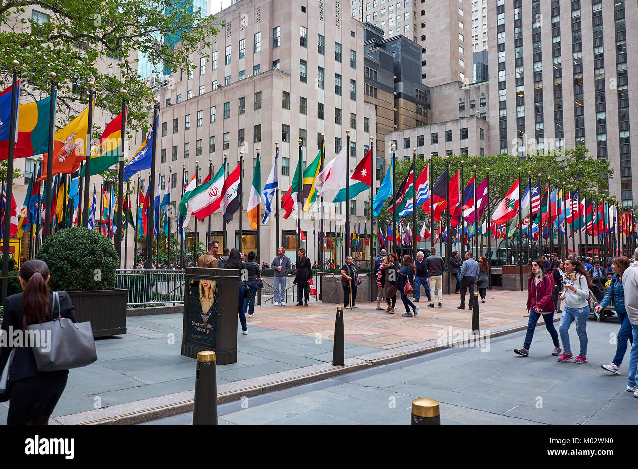 NEW YORK CITY - Settembre 29, 2016: molte persone che camminano sulla pedonale sono intorno al Rockefeller Plaza con tutte le bandiere Foto Stock