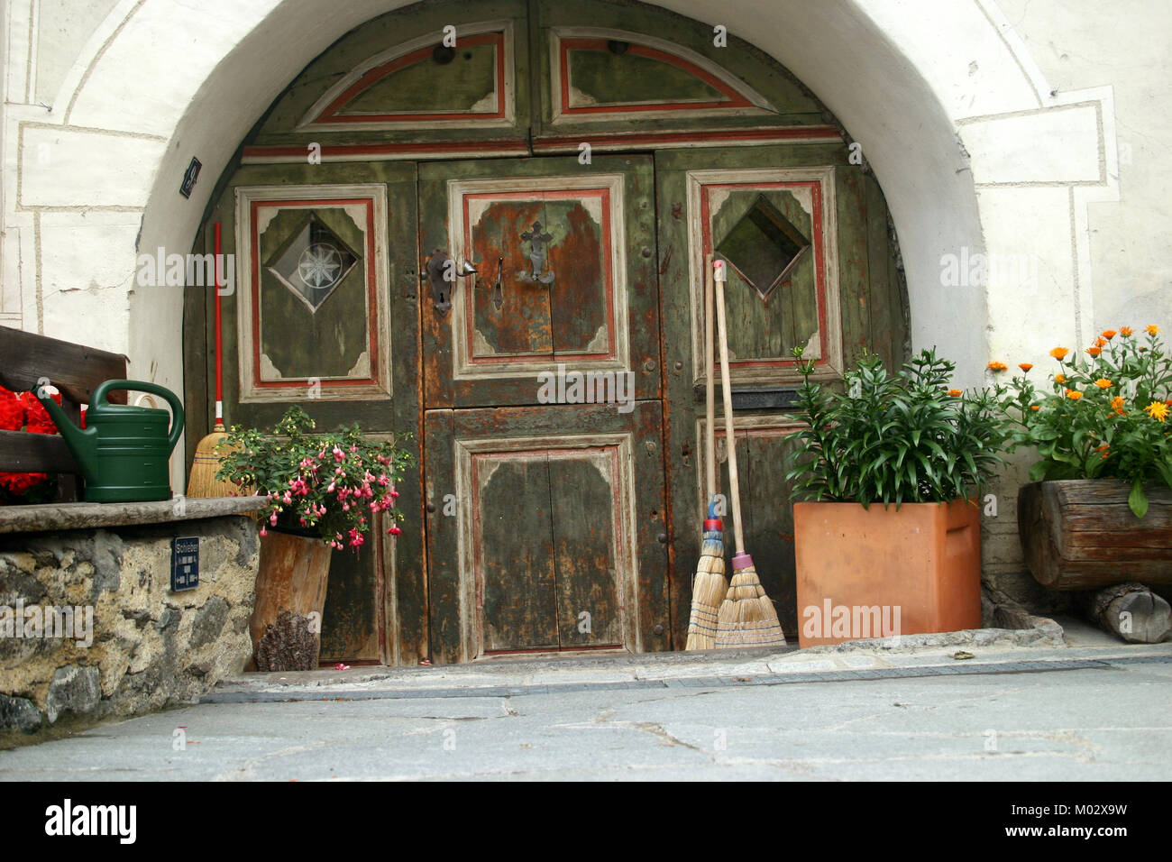 Grandi in legno porta ad arco in corrispondenza di case a Guarda, Svizzera Foto Stock