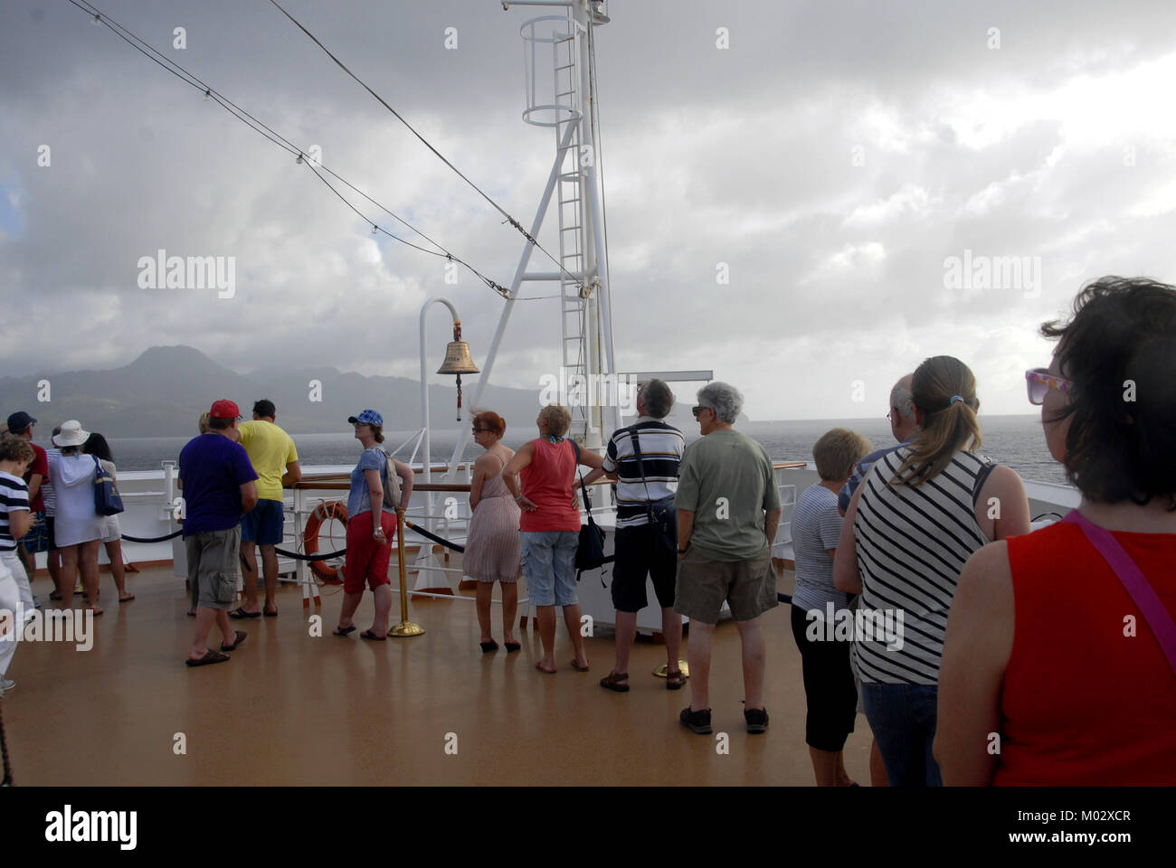 I passeggeri sul ponte della nave da crociera cercando apprehensively a pioggia nuvole sopra Foto Stock