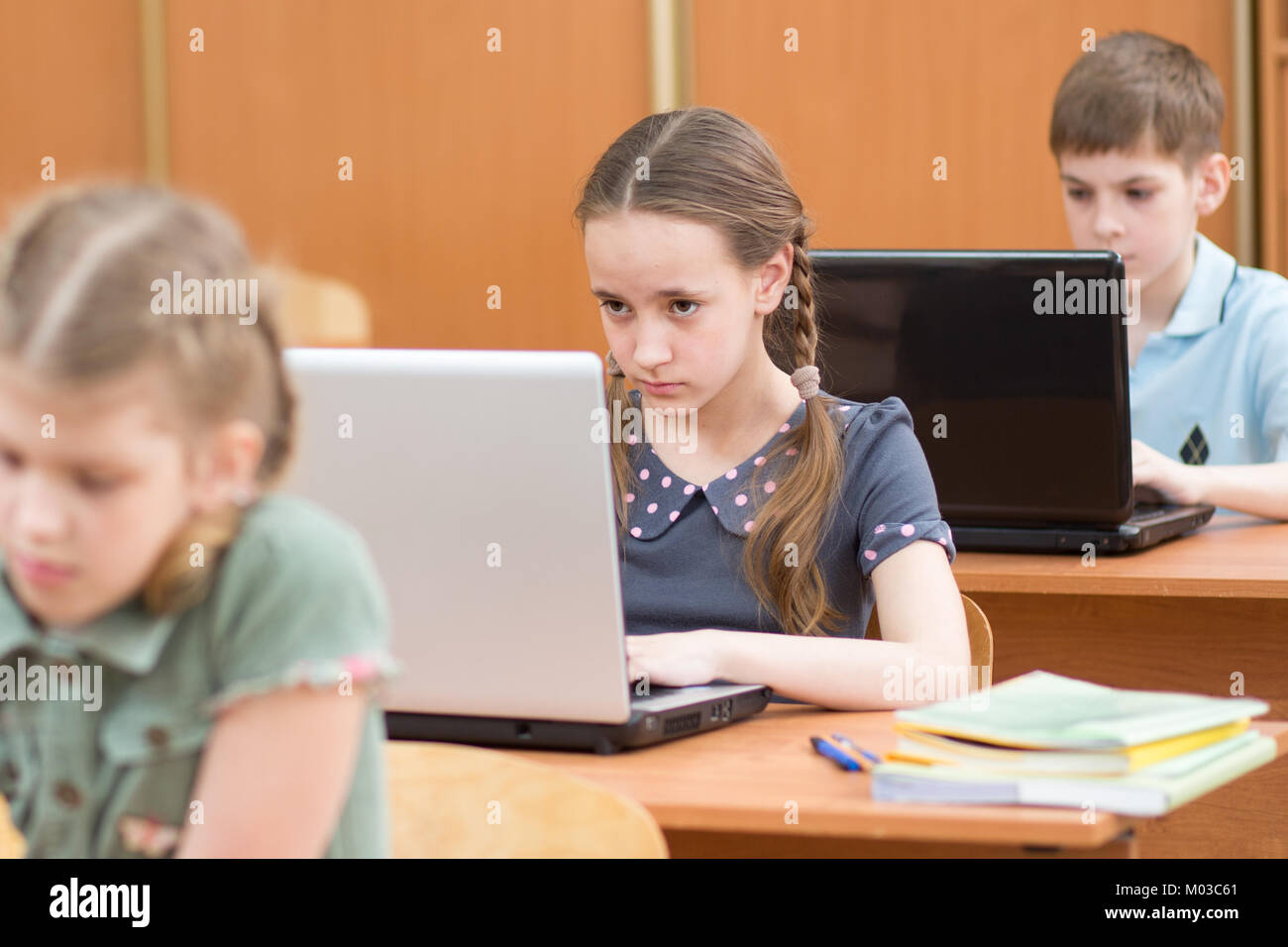 La scuola dei bambini utilizzando laptop a lezione in aula Foto Stock