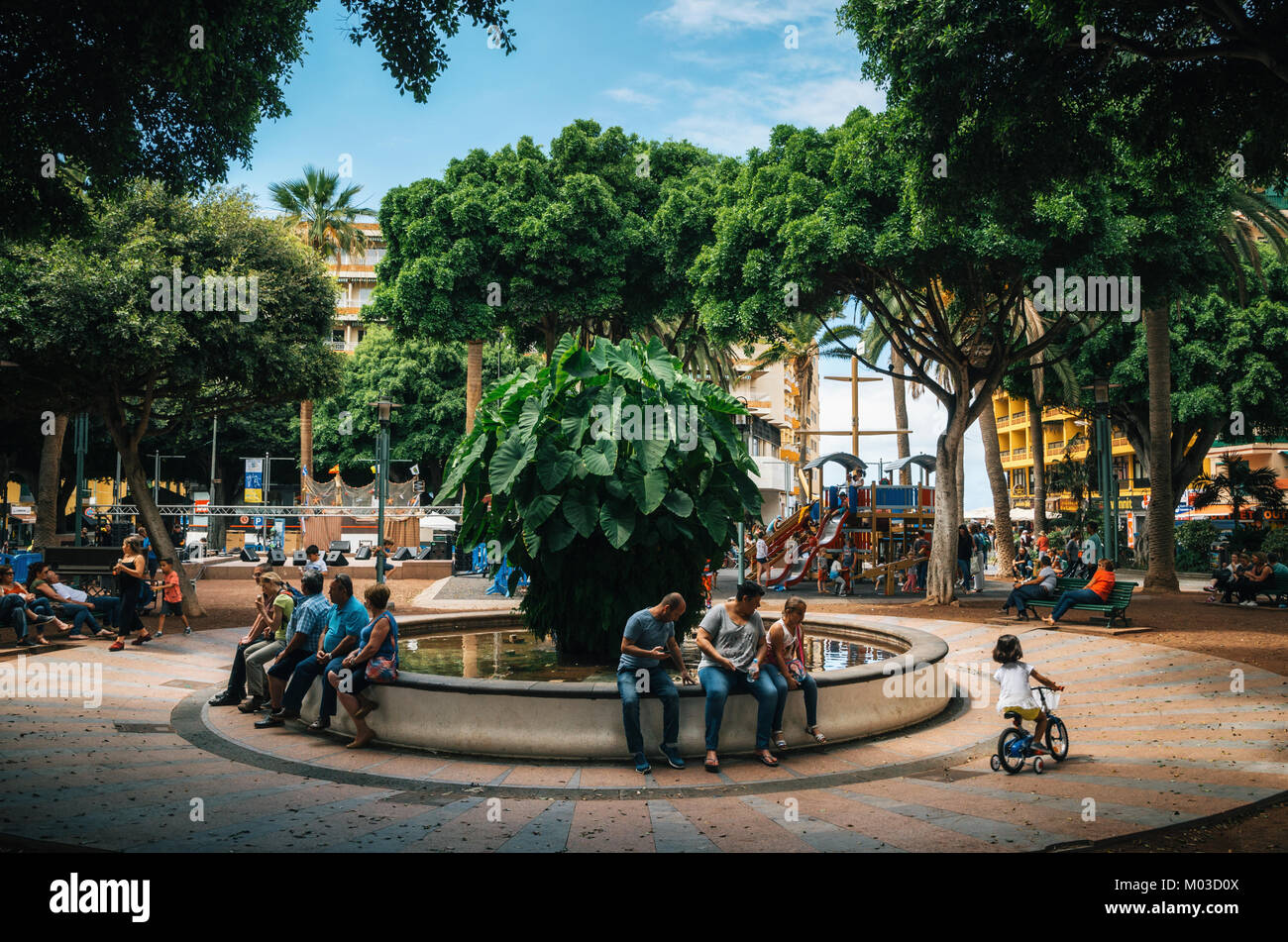 Puerto de la Cruz, Tenerife, Isole canarie, Spagna - 30 maggio 2017. Quadrato di Charco. Persone locali e turisti resto da fontana in lussureggianti corona di tr Foto Stock