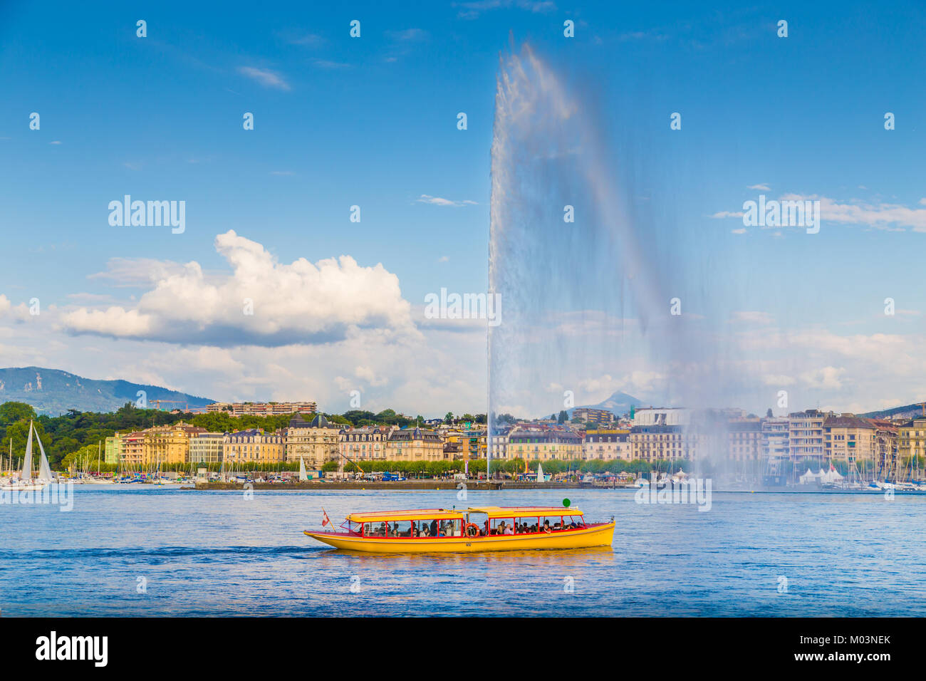Splendida vista sullo skyline di Ginevra con la famosa fontana Jet d'Eau al quartiere portuale nella bella luce della sera, Svizzera Foto Stock