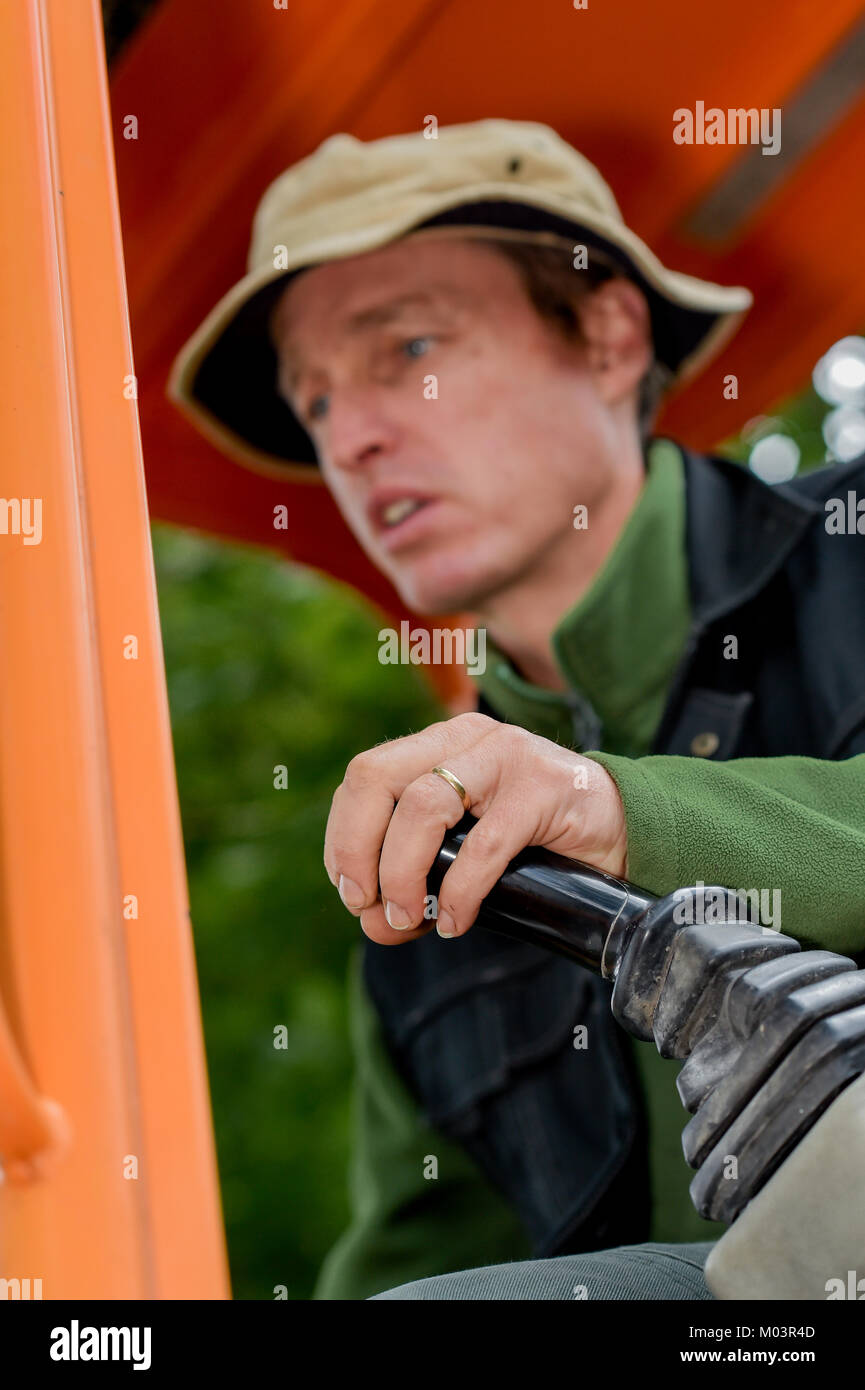 Builder alla guida di un escavatore Foto Stock