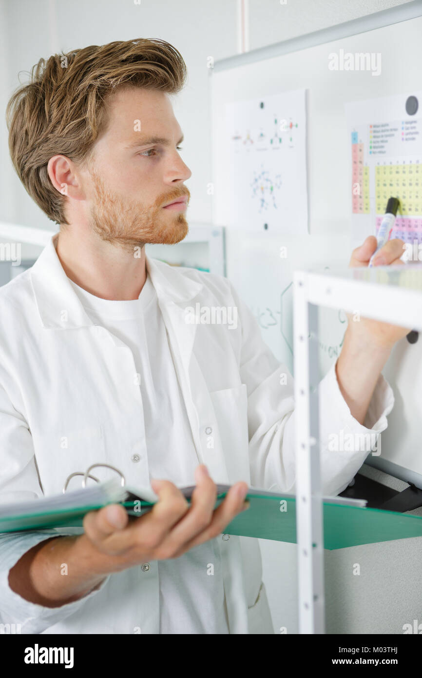 Uomo di ispezionare il prodotto chimico nel tubo Foto Stock